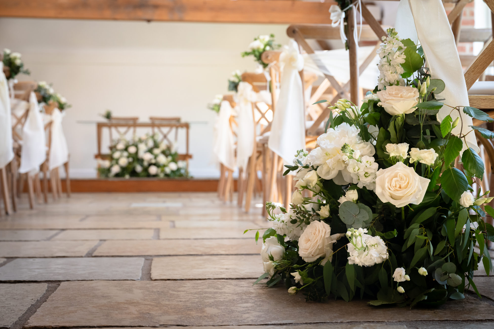 A close-up of a floral arrangement in the wedding ceremony room at Hanbury Barns.