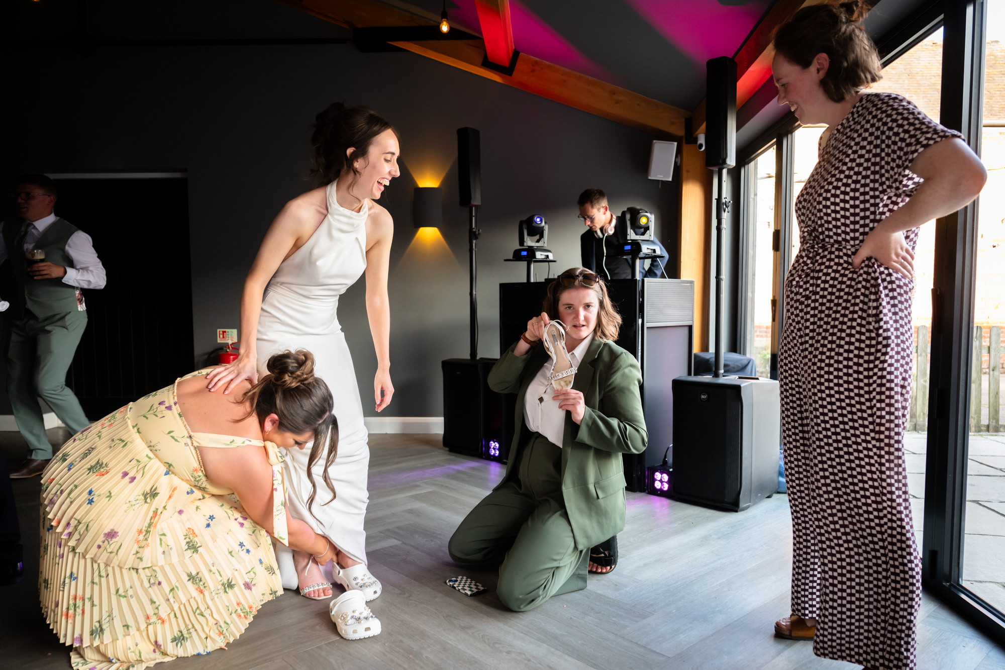 The bride is changing her shoes on the dancefloor at Hanbury Barns