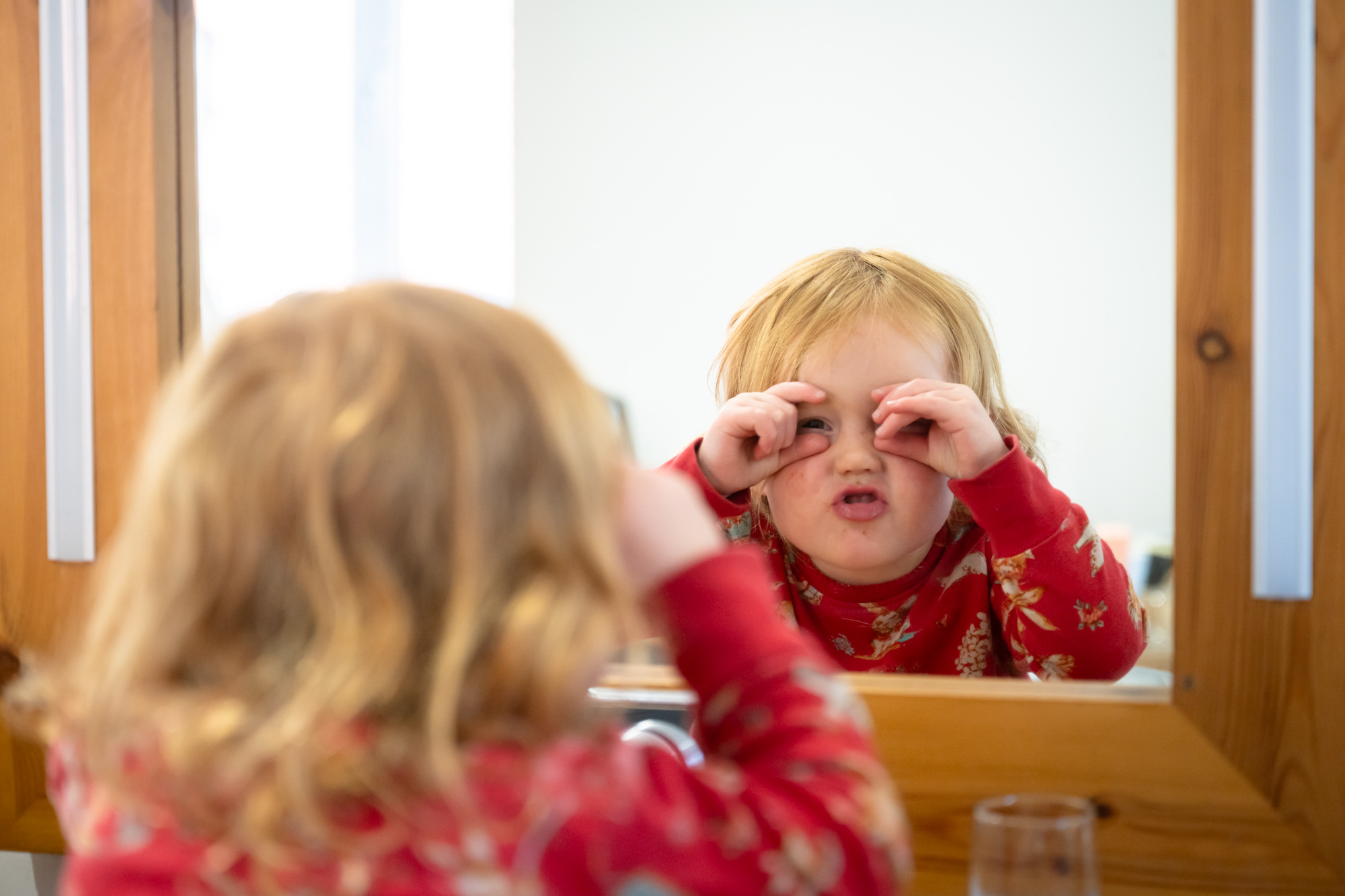 A young girl makes a funny face in a mirror while getting ready in the dressing room at Hanbury Barns.