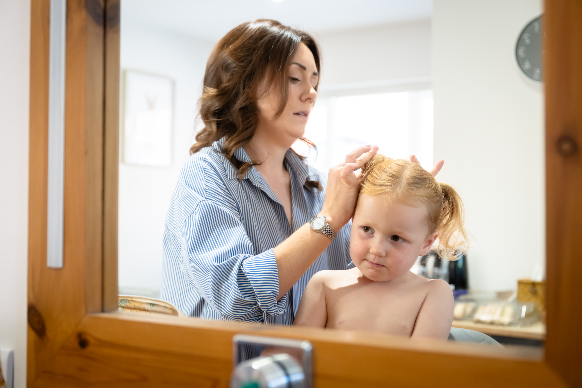 A woman styles a young girl's hair in the dressing room at Hanbury Barns.