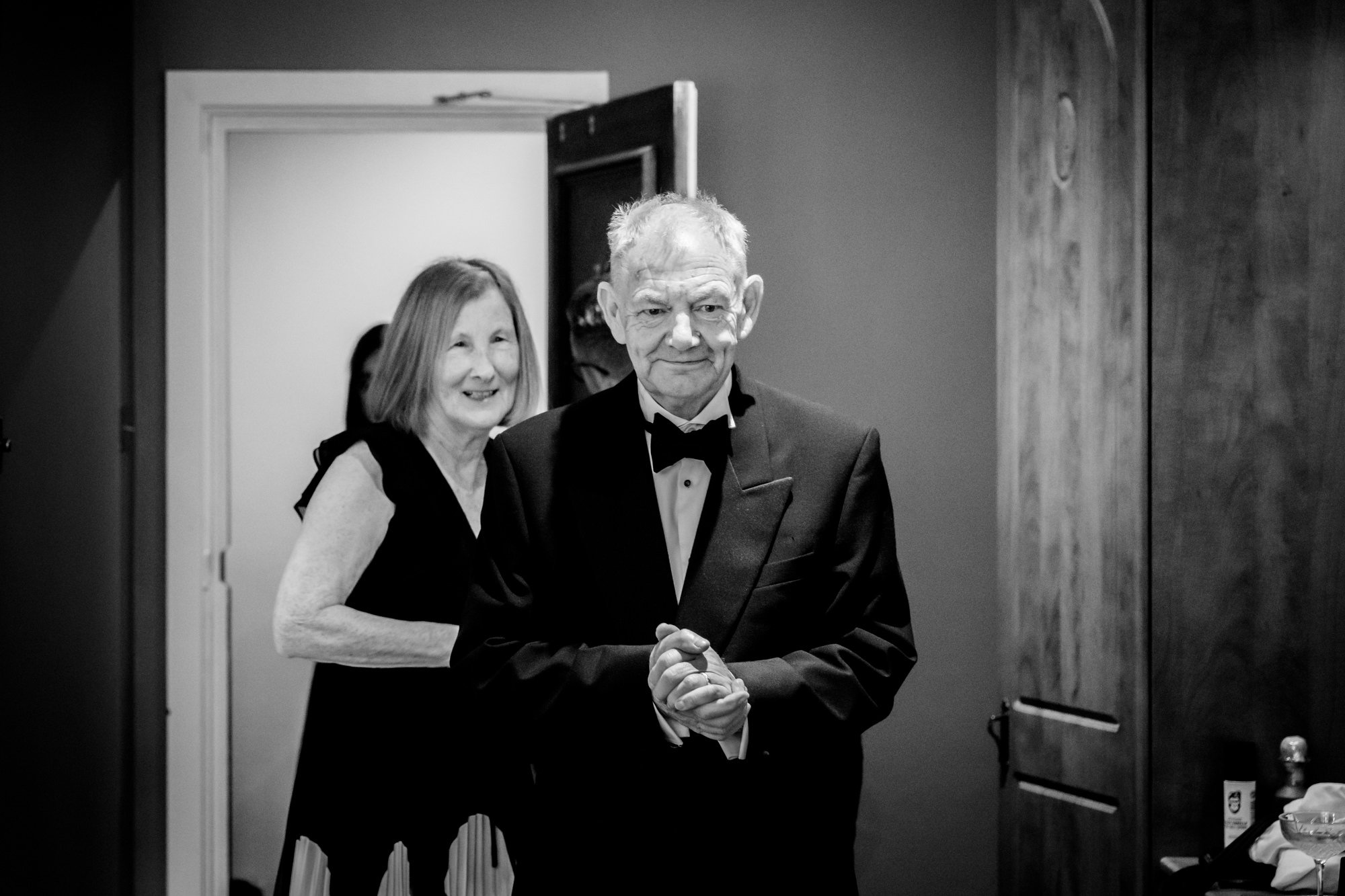 A black and white portrait of an older man and a woman smiling at the wedding at Springbank Manor.