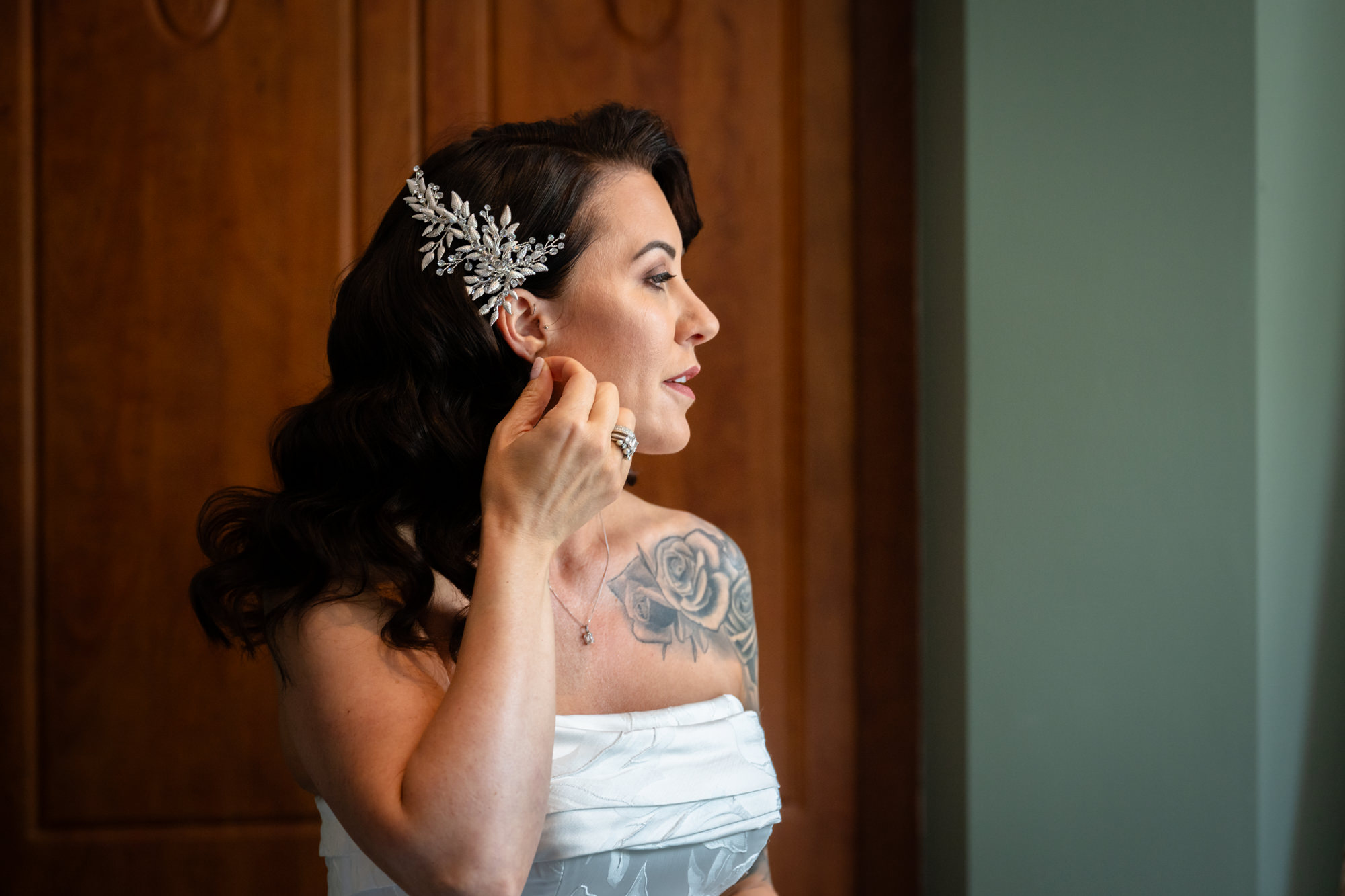A close-up side profile of the bride in the white dress, with a decorative floral clip in her hair, at Springbank Manor.