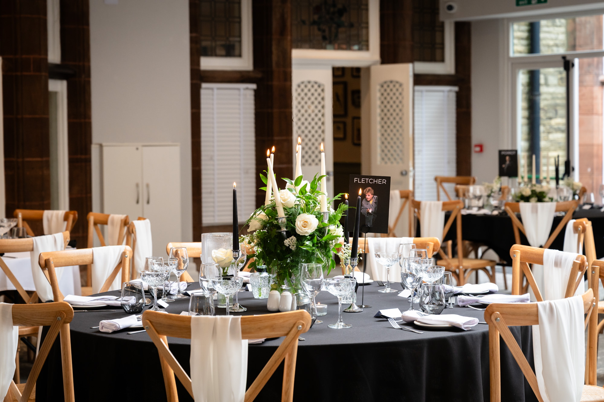 A table is set with a black tablecloth and a floral centerpiece at Springbank Manor.