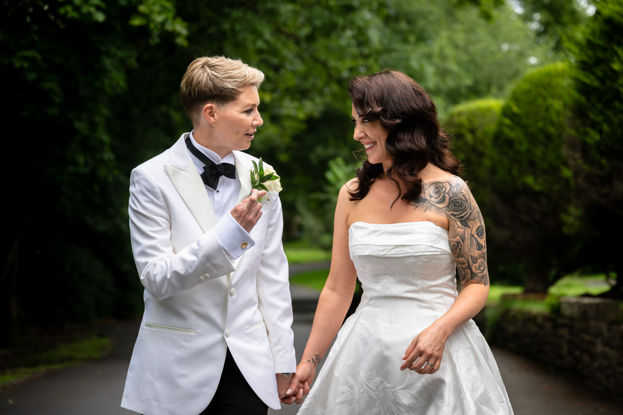 A portrait of the two brides, holding hands and smiling at each other at Springbank Manor.