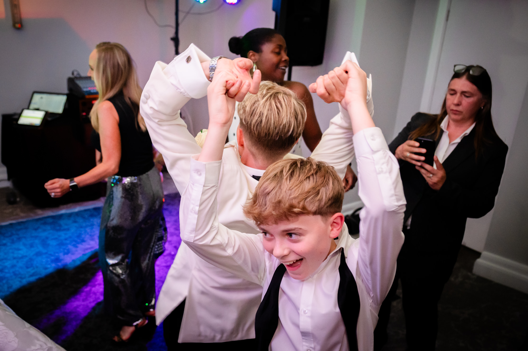 bride in a white tuwedo dancing with a young boy at Springbank Manor.
