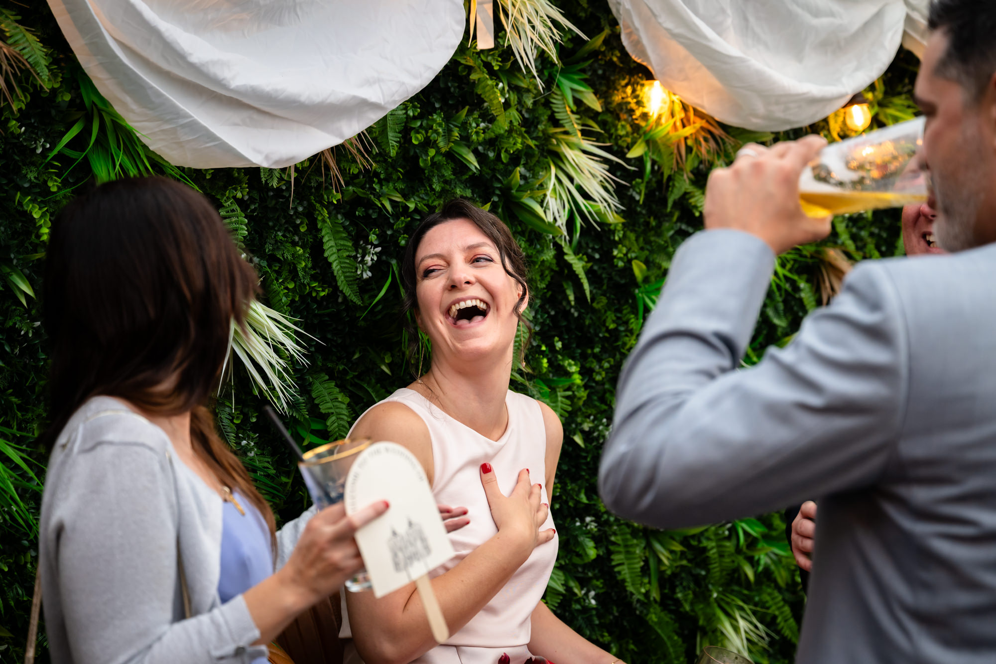 A guest smiles and laughs while sitting outside.