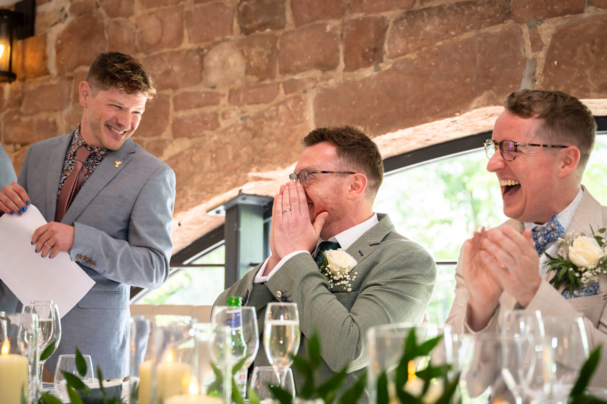 The grooms listen to the speeches, and looking embarrassed