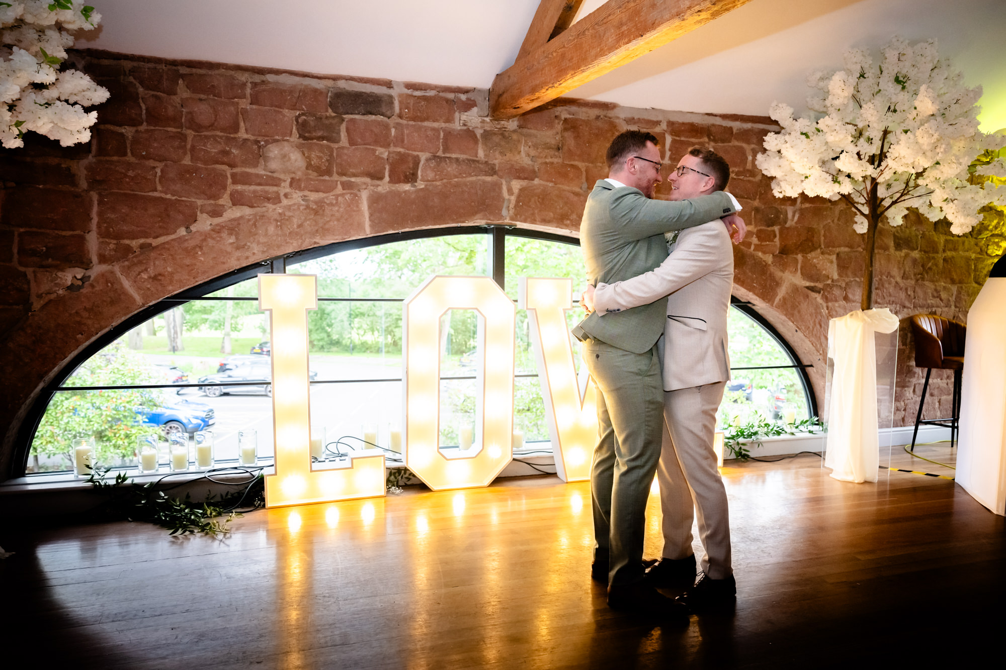 The grooms embrace and dance together during their first dance at Allerton Manor.