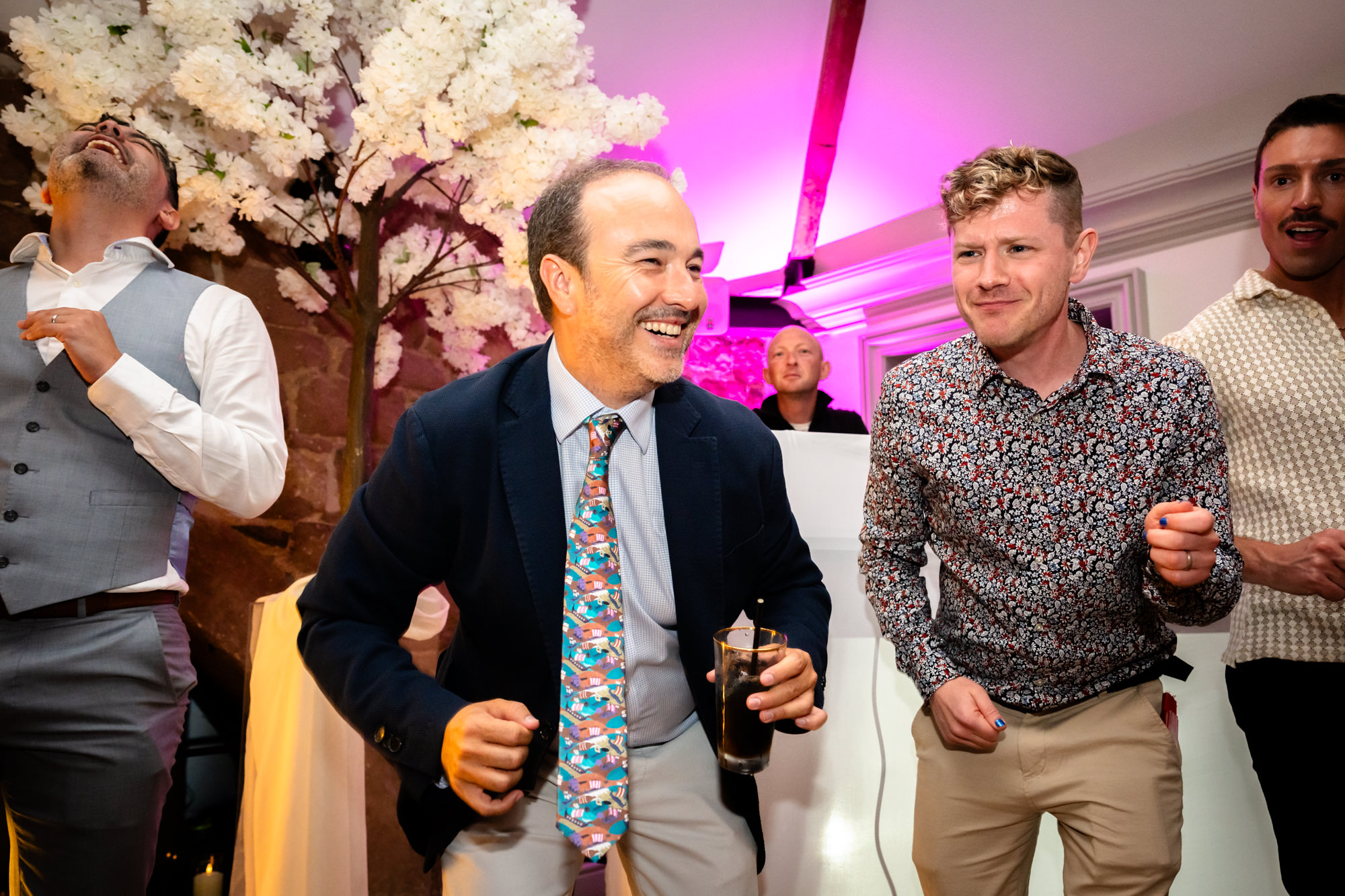 Two guests are dancing together at the wedding party.