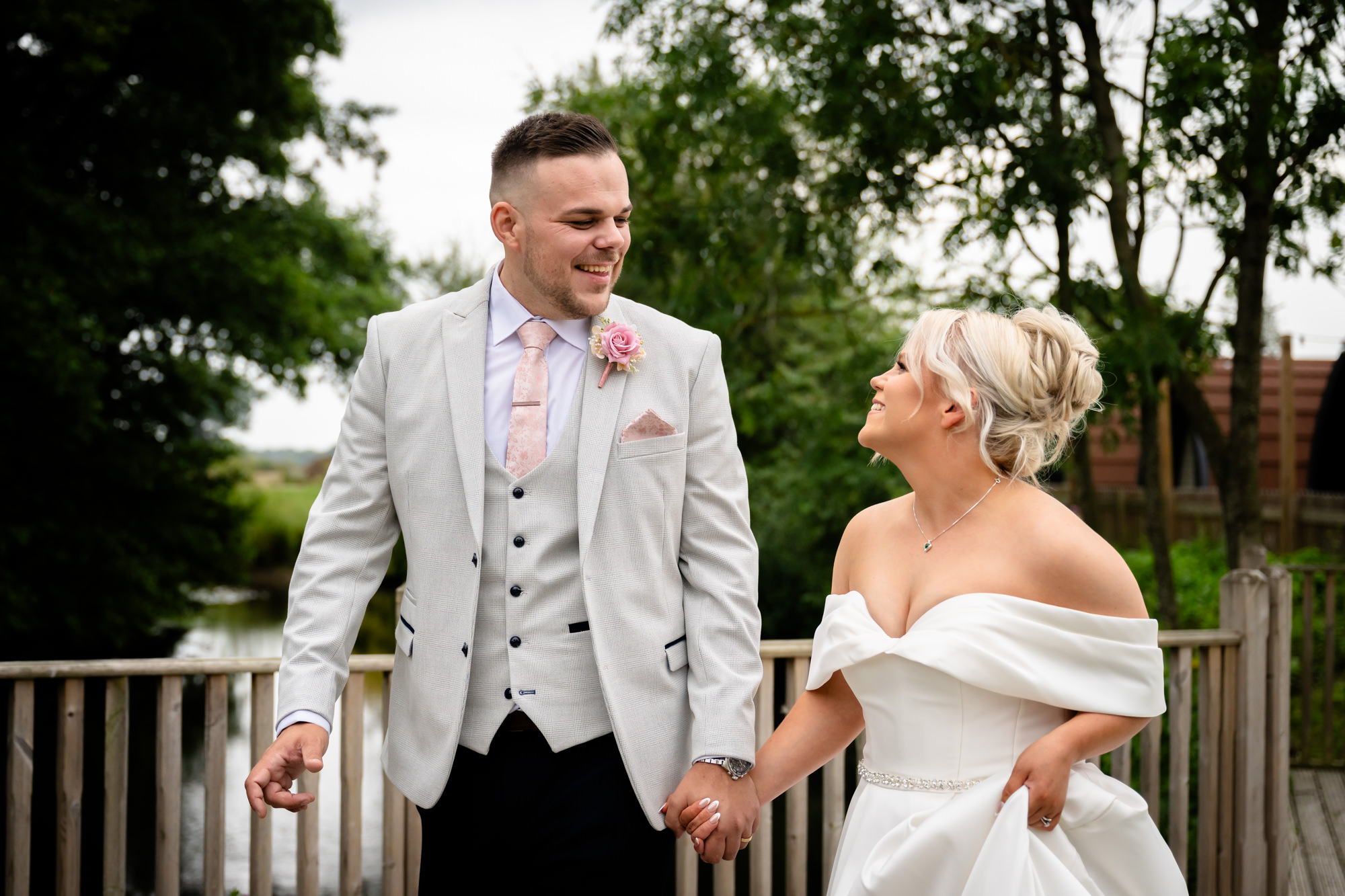 A lovely portrait from the wedding at Hanbury Barns showing the happy couple walking towards the camera and holding hands on the wooden decking.