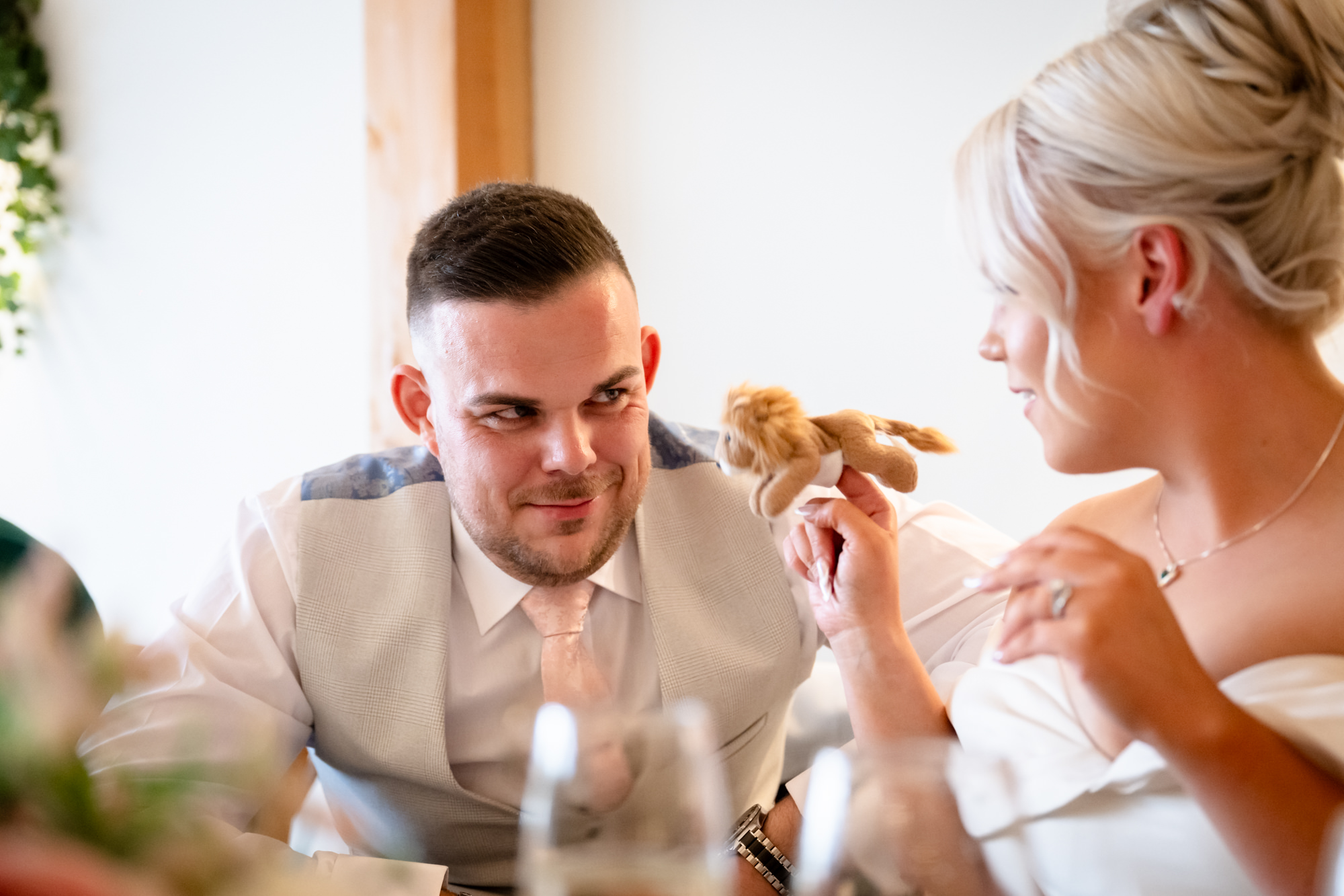 The bride is showing a finger puppet to the groom