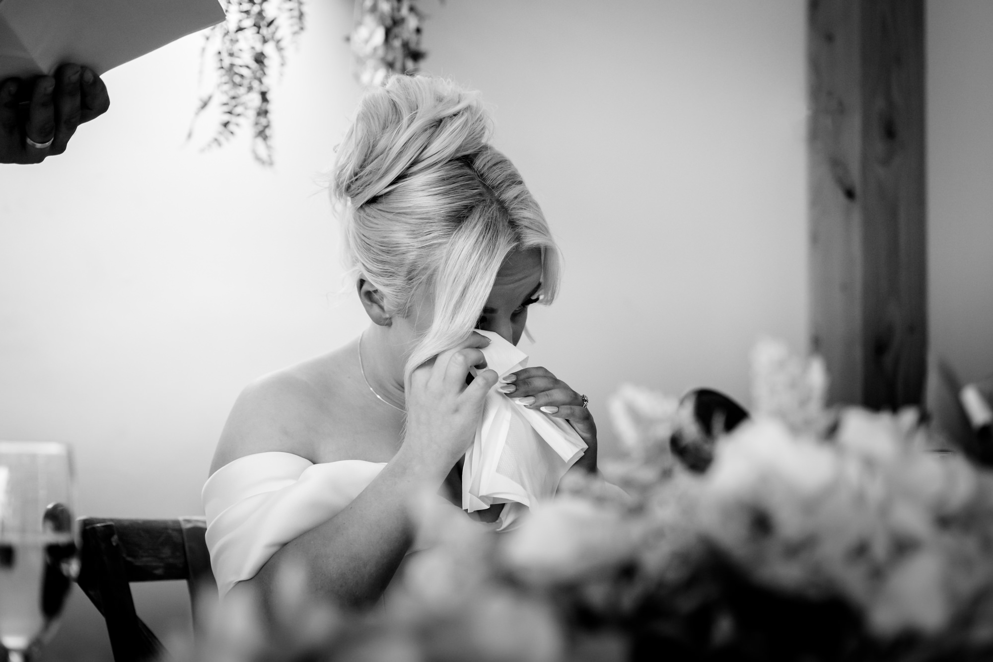 The bride wiping a tear during the speeches