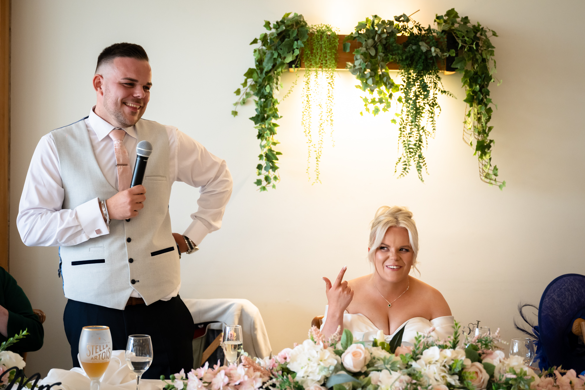 A romantic wedding moment at Hanbury Barns showing the groom giving his speech with a pink necktie