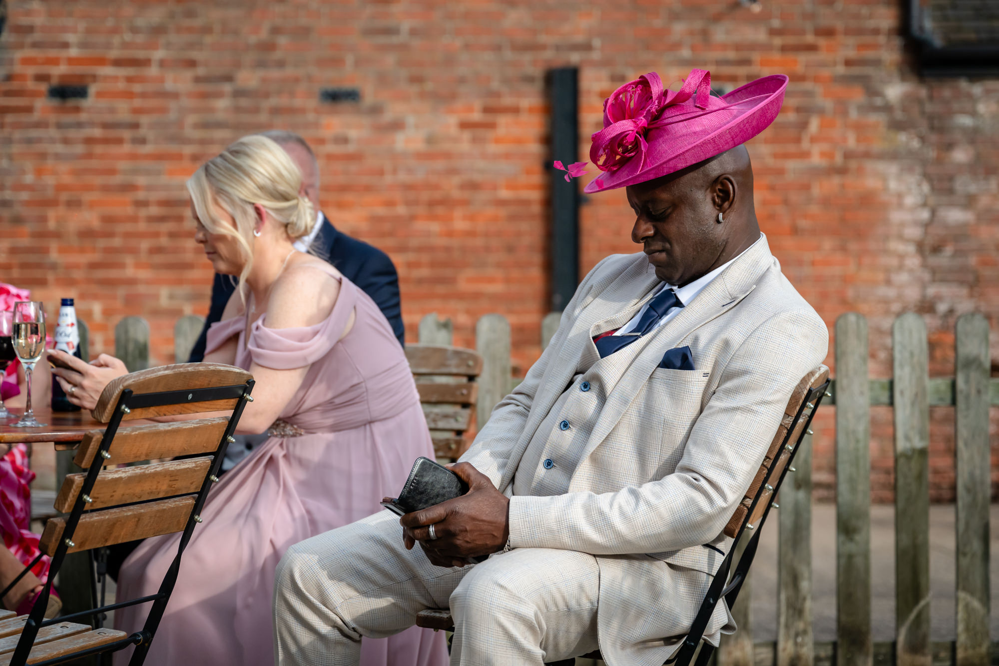 A man sat outside wearing a pink hat