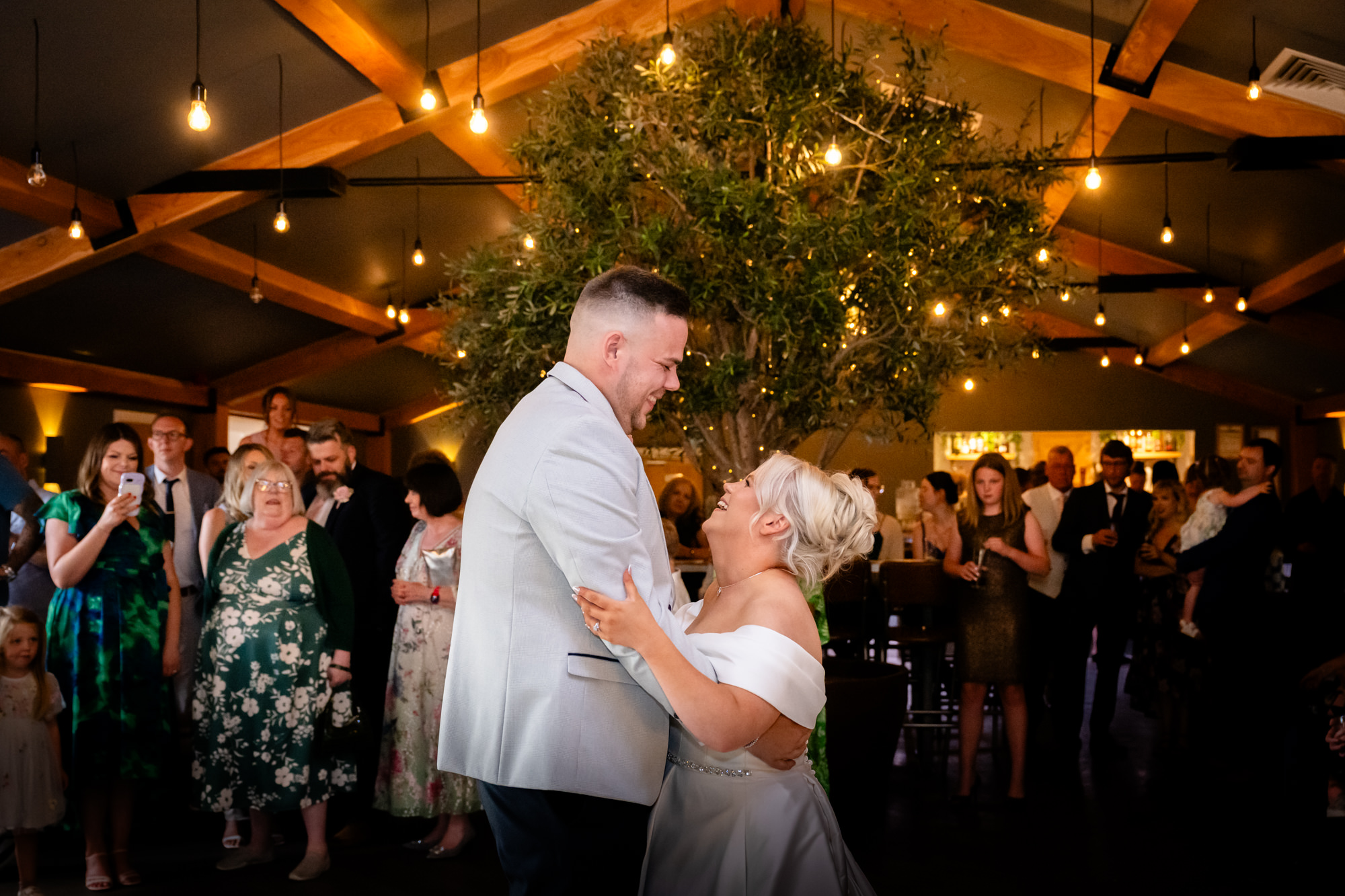The dance floor is lit up with guests dancing around the happily married couple during the evening reception at Hanbury Barns.