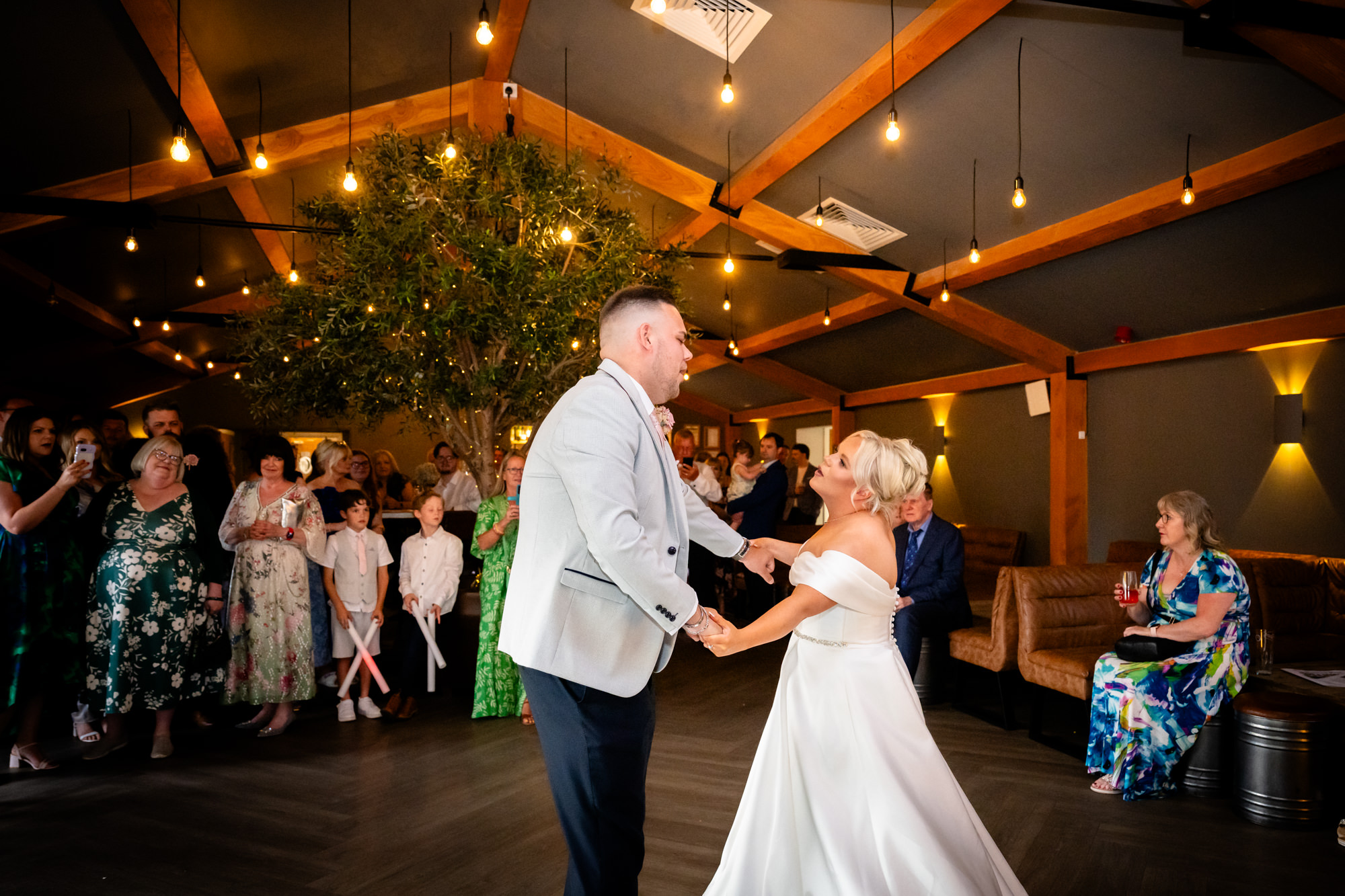 A close-up of the bride and groom sharing a loving embrace and slow dance during their first dance at Hanbury Barns.