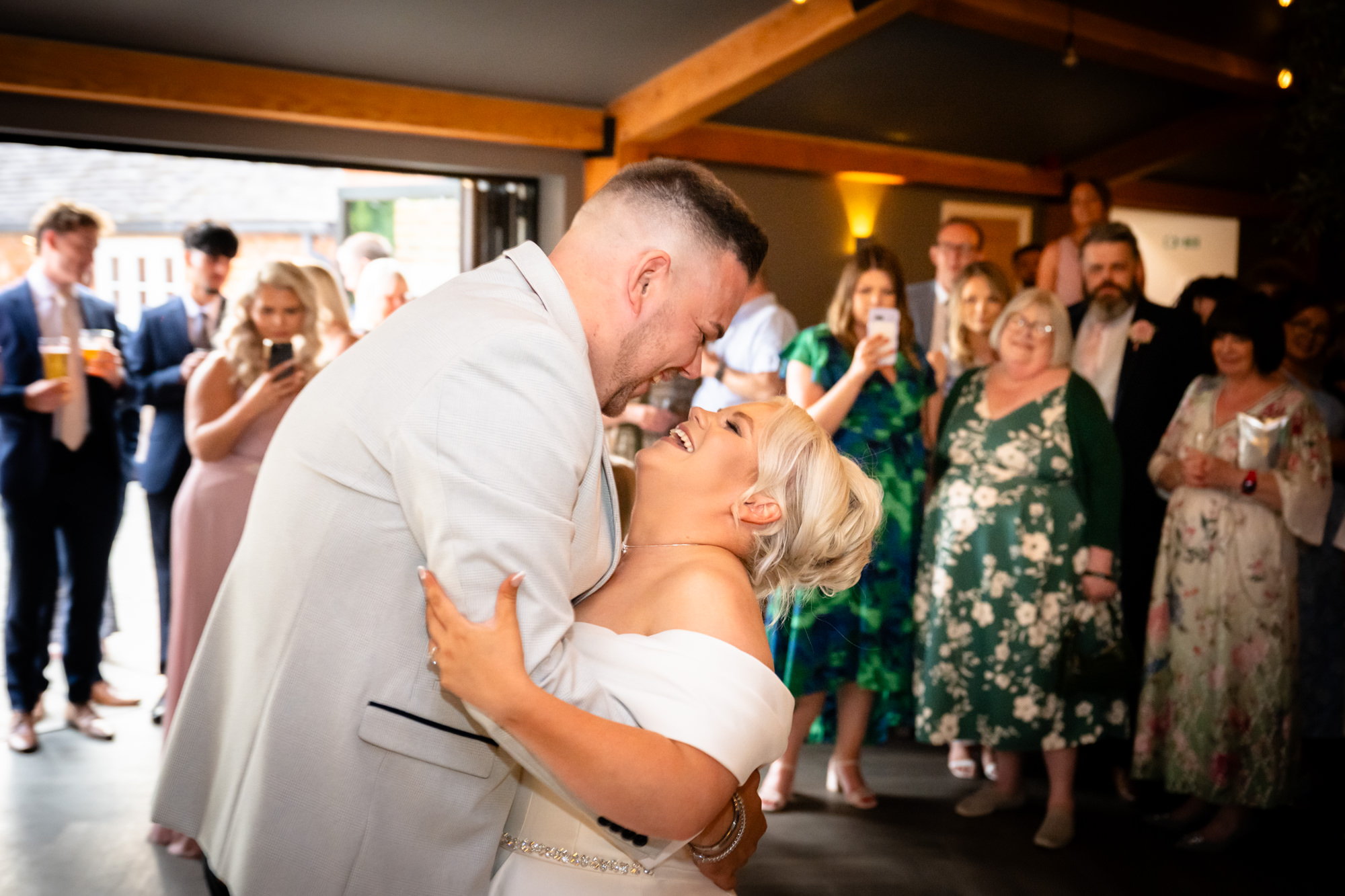 A fun photo from the wedding at Hanbury Barns capturing the bride dancing enthusiastically with a friend on the crowded dance floor.