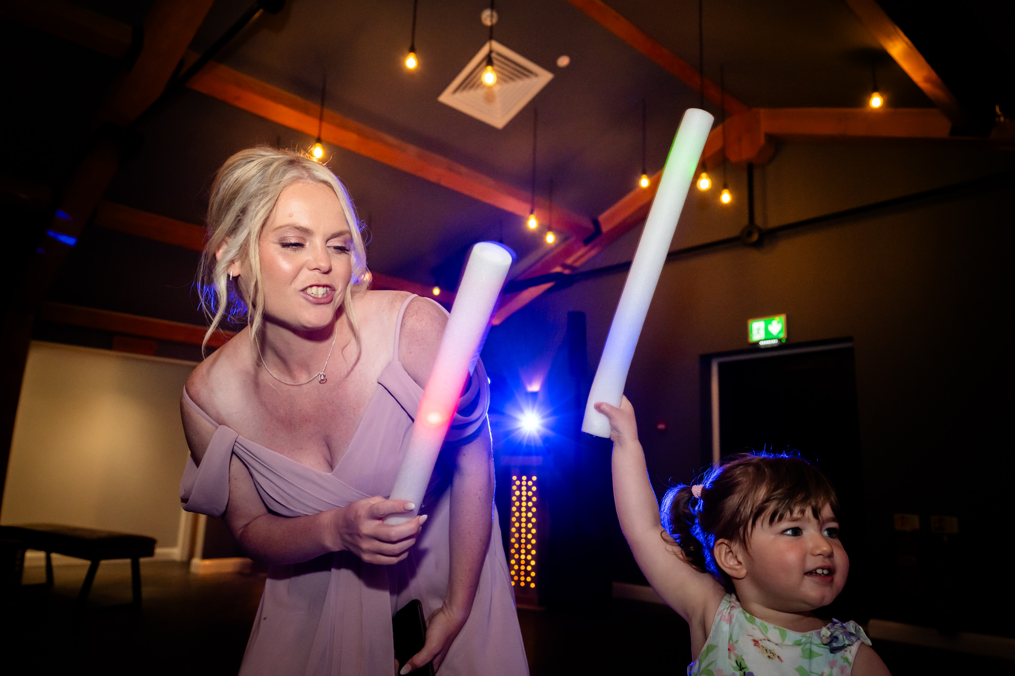 A dynamic photo capturing the joy and energy of the wedding party dancing and celebrating inside Hanbury Barns.