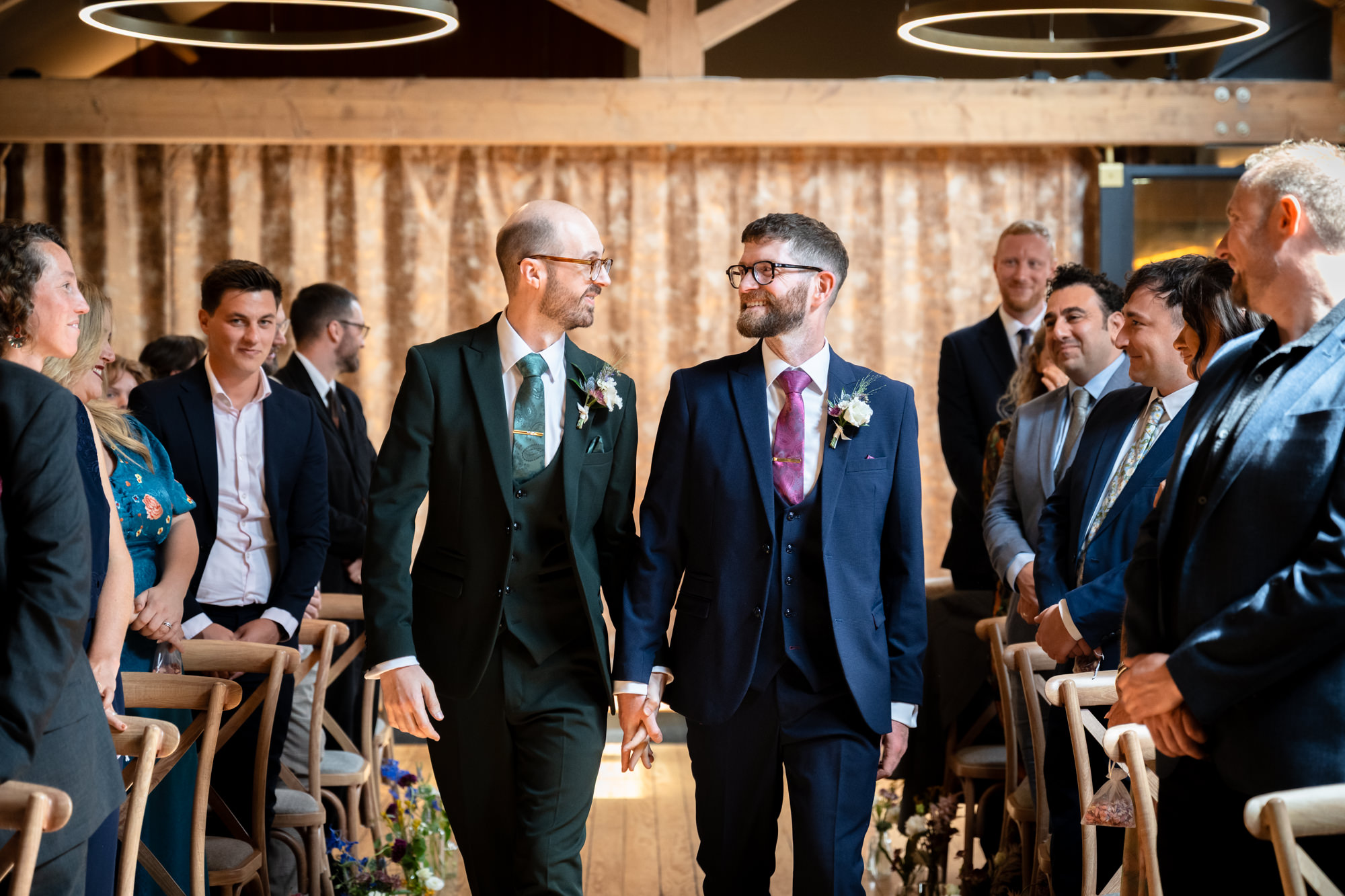 Guests stand and laugh together on a sunny outdoor terrace, enjoying the pre-ceremony excitement for the Castlefield Rooms wedding.