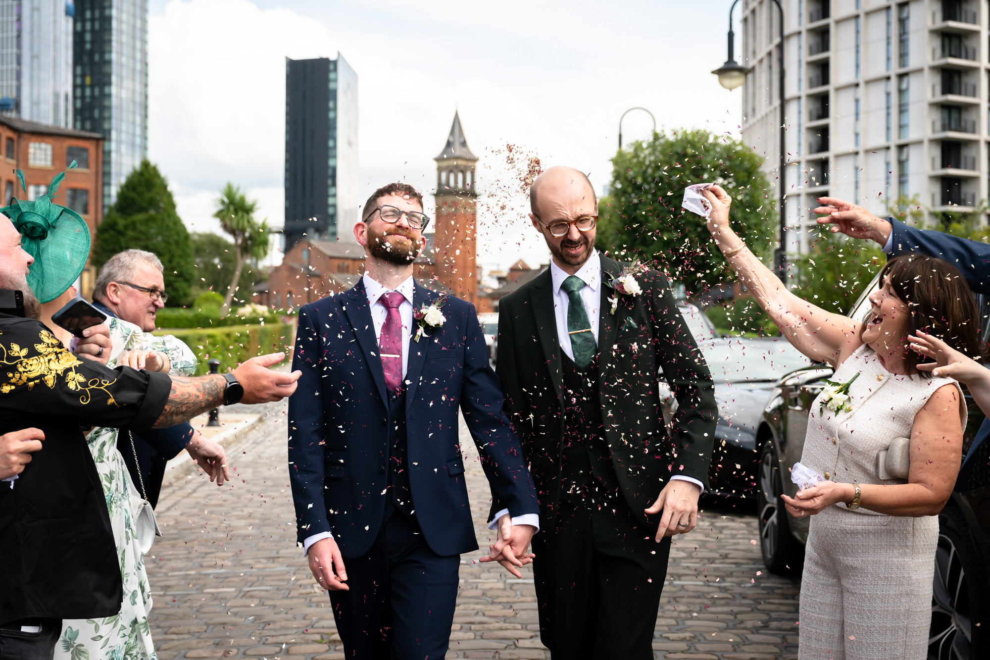 The newly married couple walks through the cheering crowd of guests after their beautiful ceremony at the Castlefield Rooms wedding.