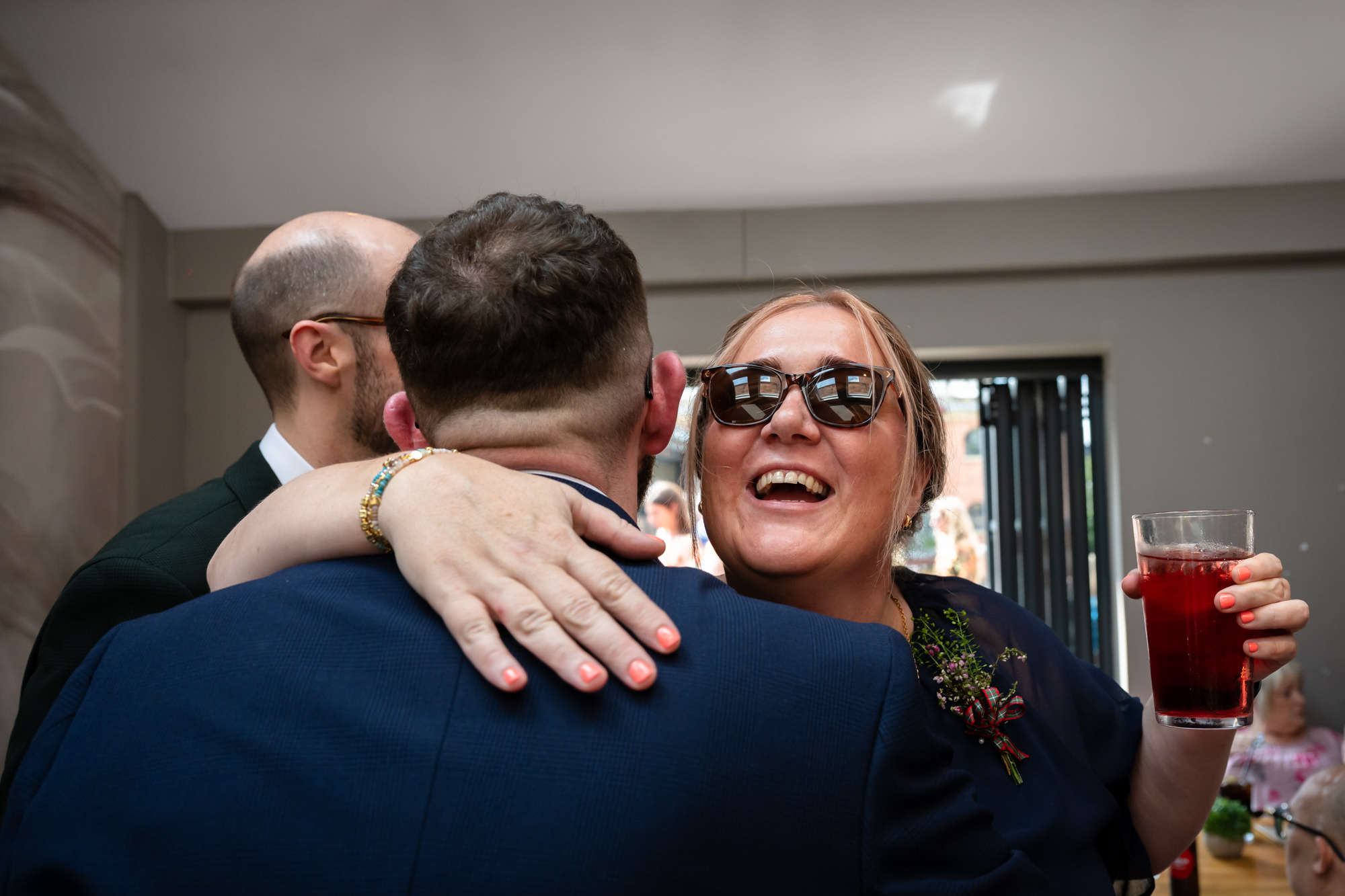 The grooms walk through the street hand-in-hand, surrounded by confetti and happy wedding guests outside Castlefield Rooms.