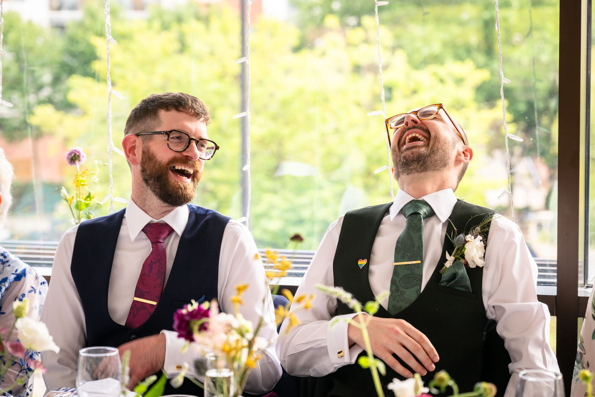Guests raise their glasses and cheer, signaling the start of the speeches during the celebratory reception at the Castlefield Rooms wedding.
