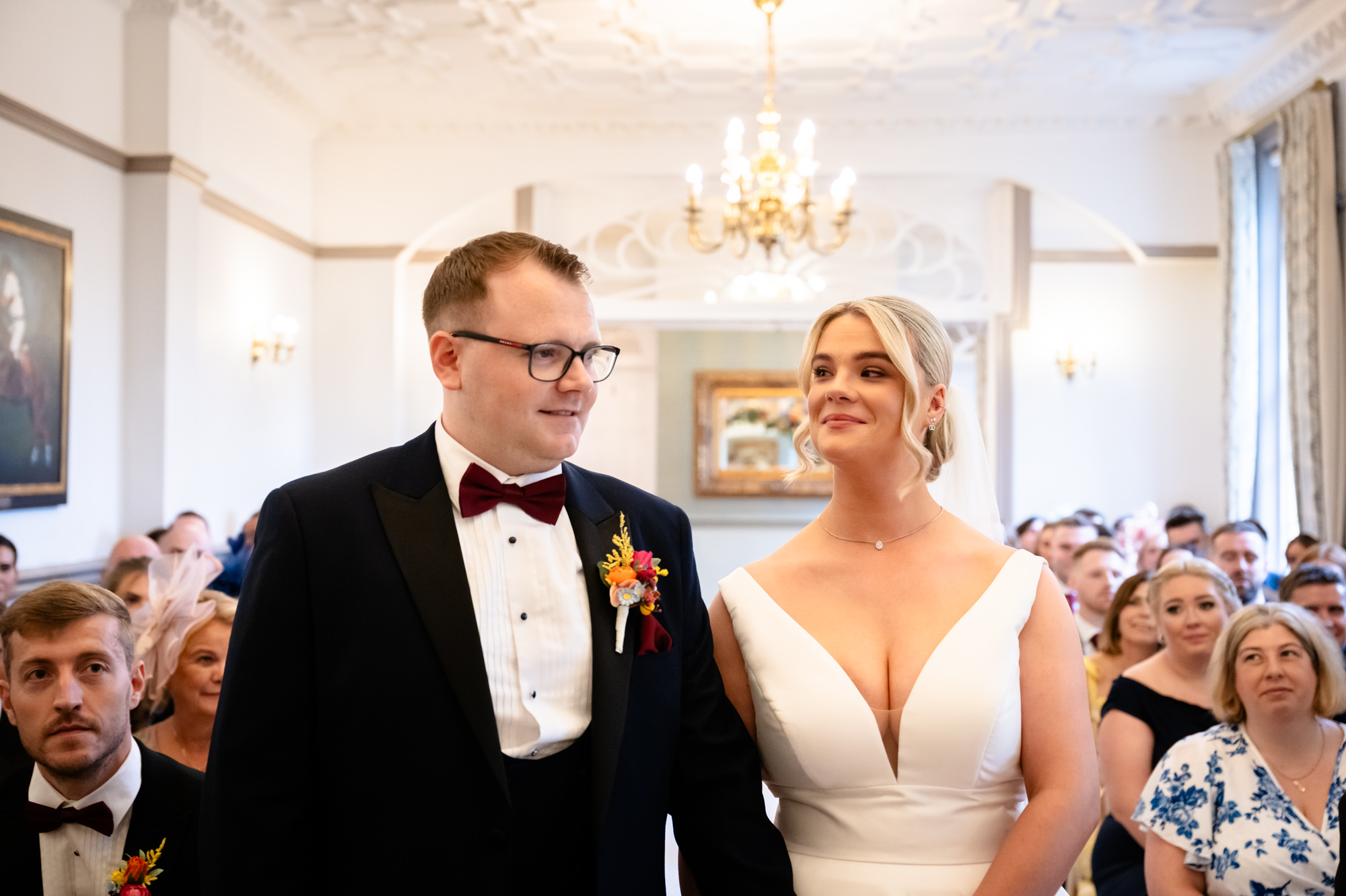 The bride and groom standing together smiling at the front of the Crystal Suite during their wedding at Nunsmere Hall.