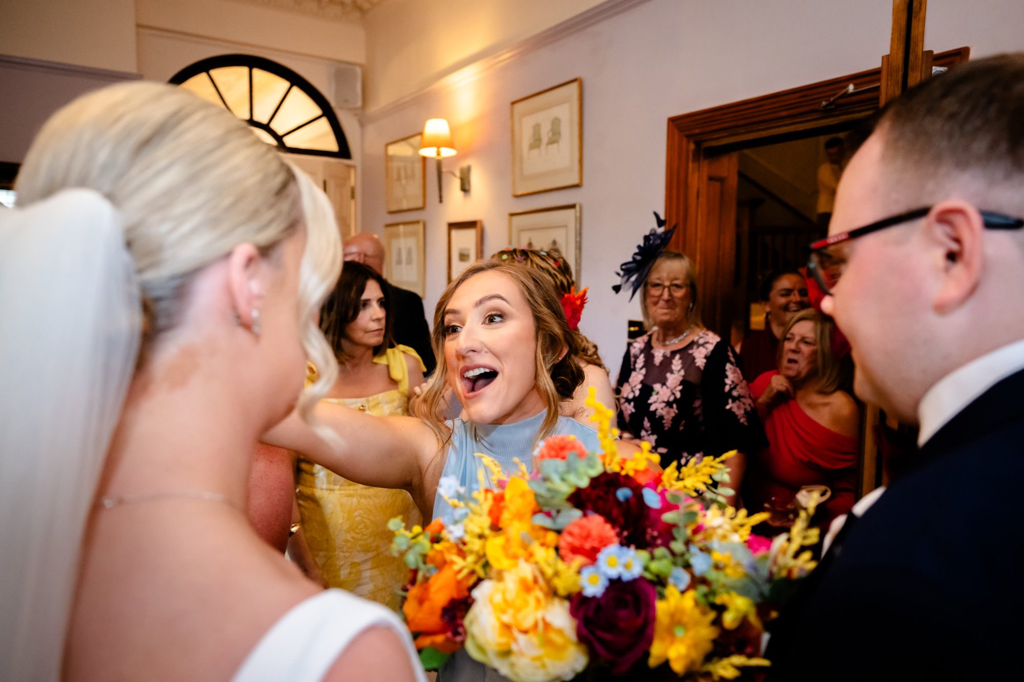 The smiling bride hugging a guest during the drinks reception of a wedding at Nunsmere Hall.