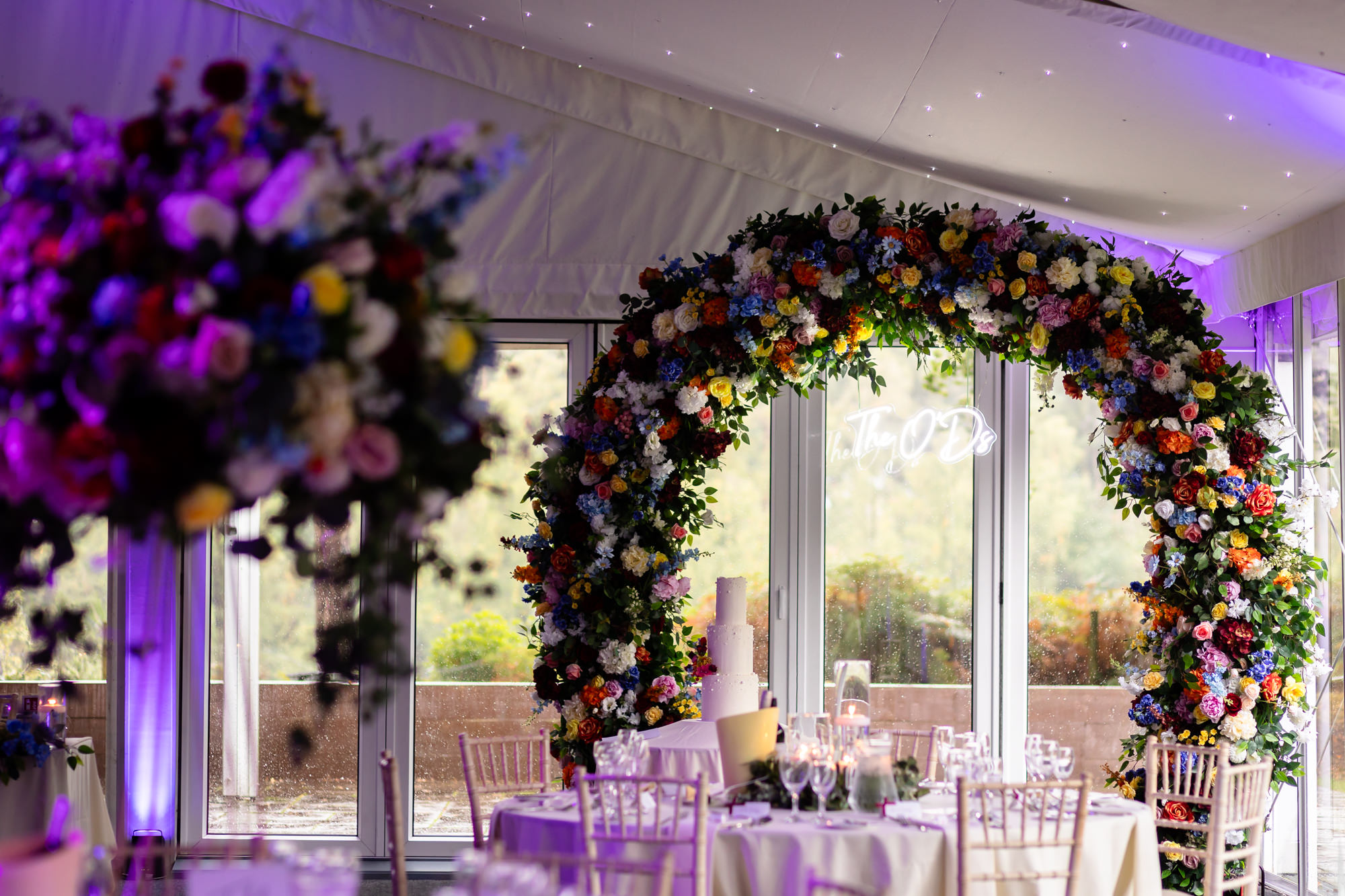 A large floral archway decorating the cake at the marquee reception at Nunsmere Hall.