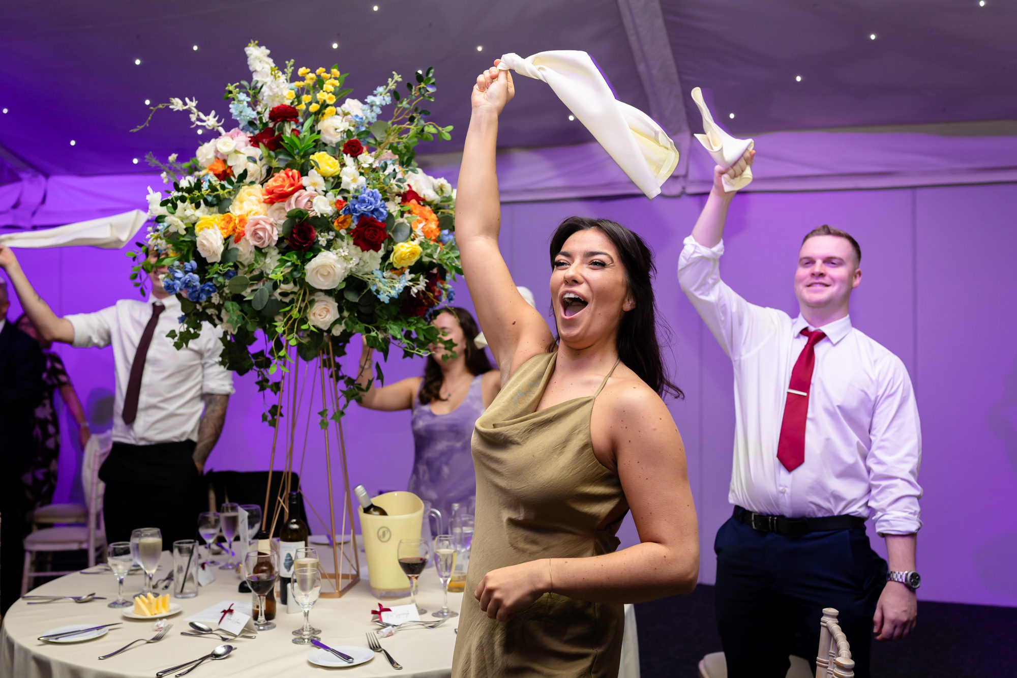 A guest waving a white napkin in the air to welcome the newlyweds to Nunsmere Hall.