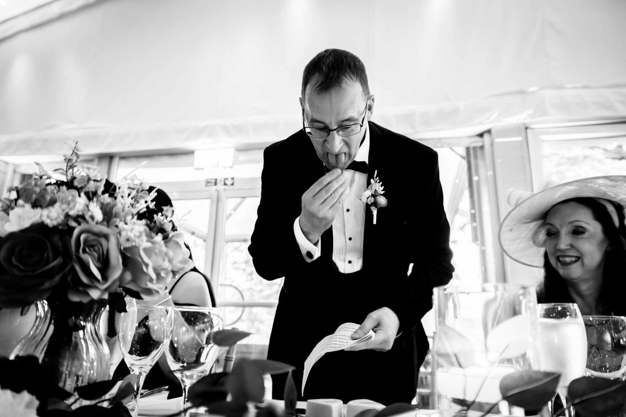 Father of the bride is licking his finger to turn the pages