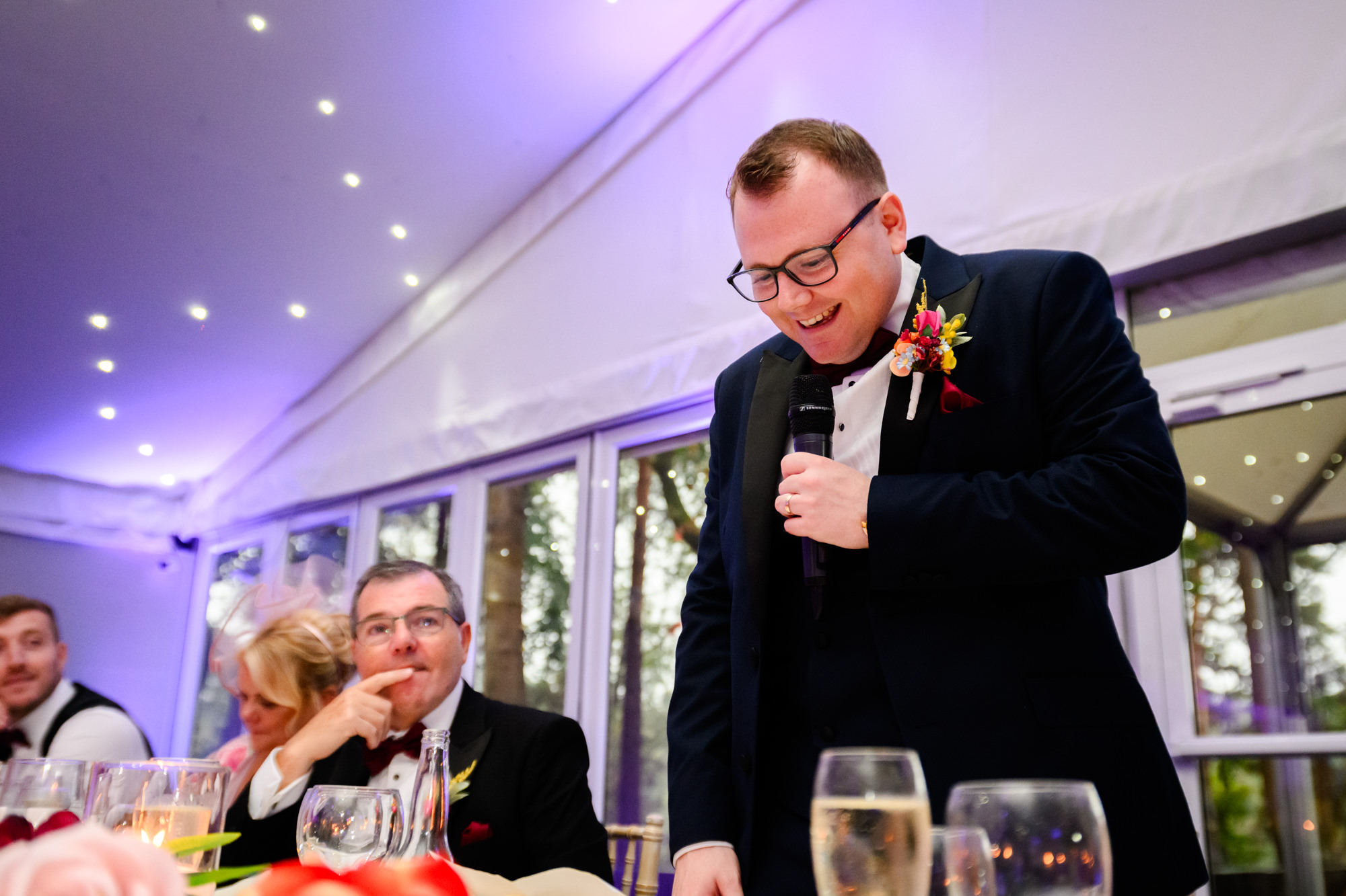 The groom giving his speech with a microphone in hand at Nunsmere Hall.