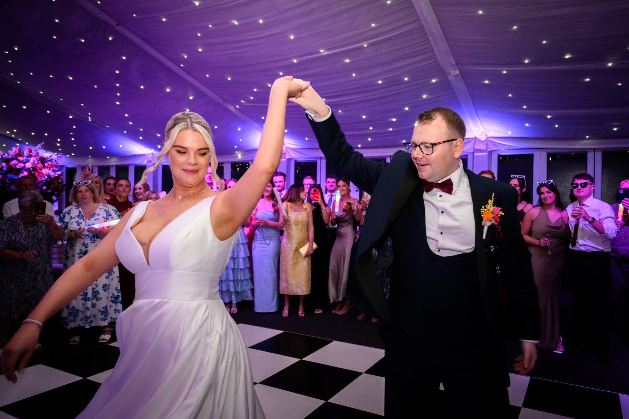 The groom spinning the bride during their first dance under the starry ceiling lights at Nunsmere Hall.