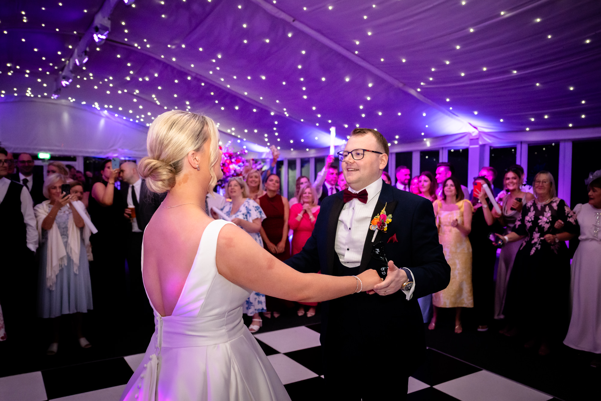 The couple holding hands and looking into each other eyes during the first dance at a wedding at Nunsmere Hall.