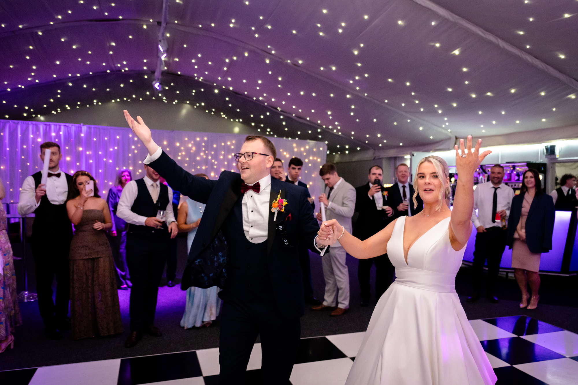 The bride and groom dancing with guests watching in the background at Nunsmere Hall.