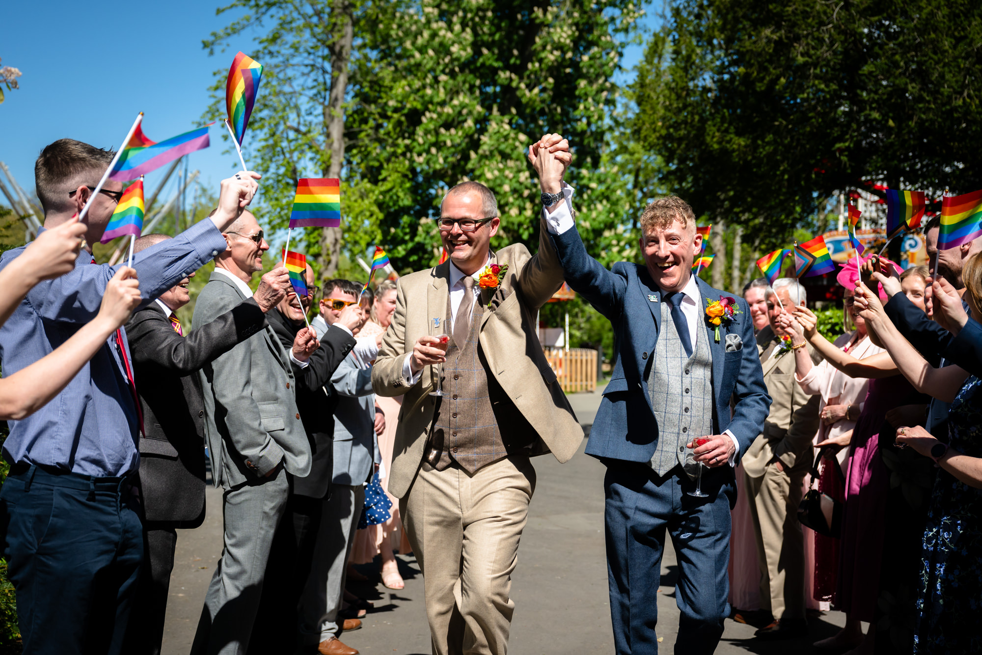 Marc and Dom walk through a guard of Pride flags outside at Chester Zoo.