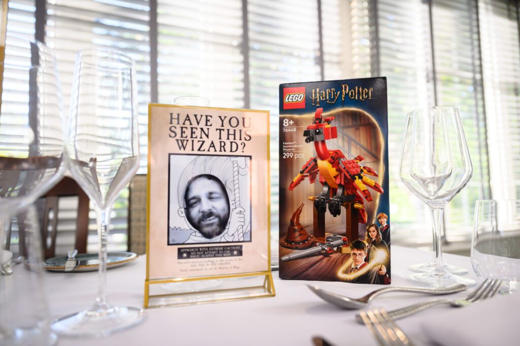 One of the "Wanted Wizard" posters featuring a guest, beside a Harry Potter Lego set.