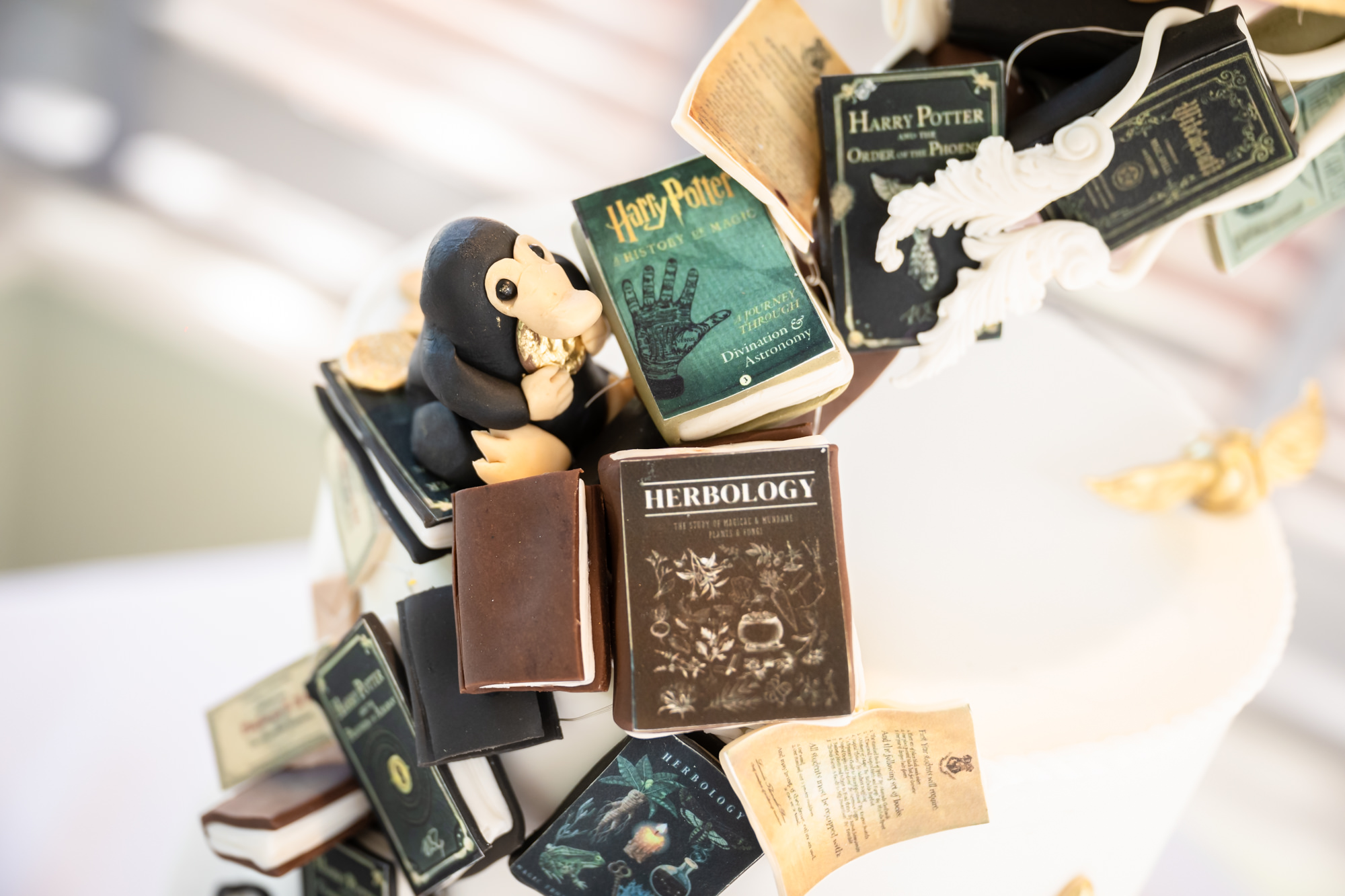 Cake detail: a Niffler and edible Harry Potter books cascading down the tiers.