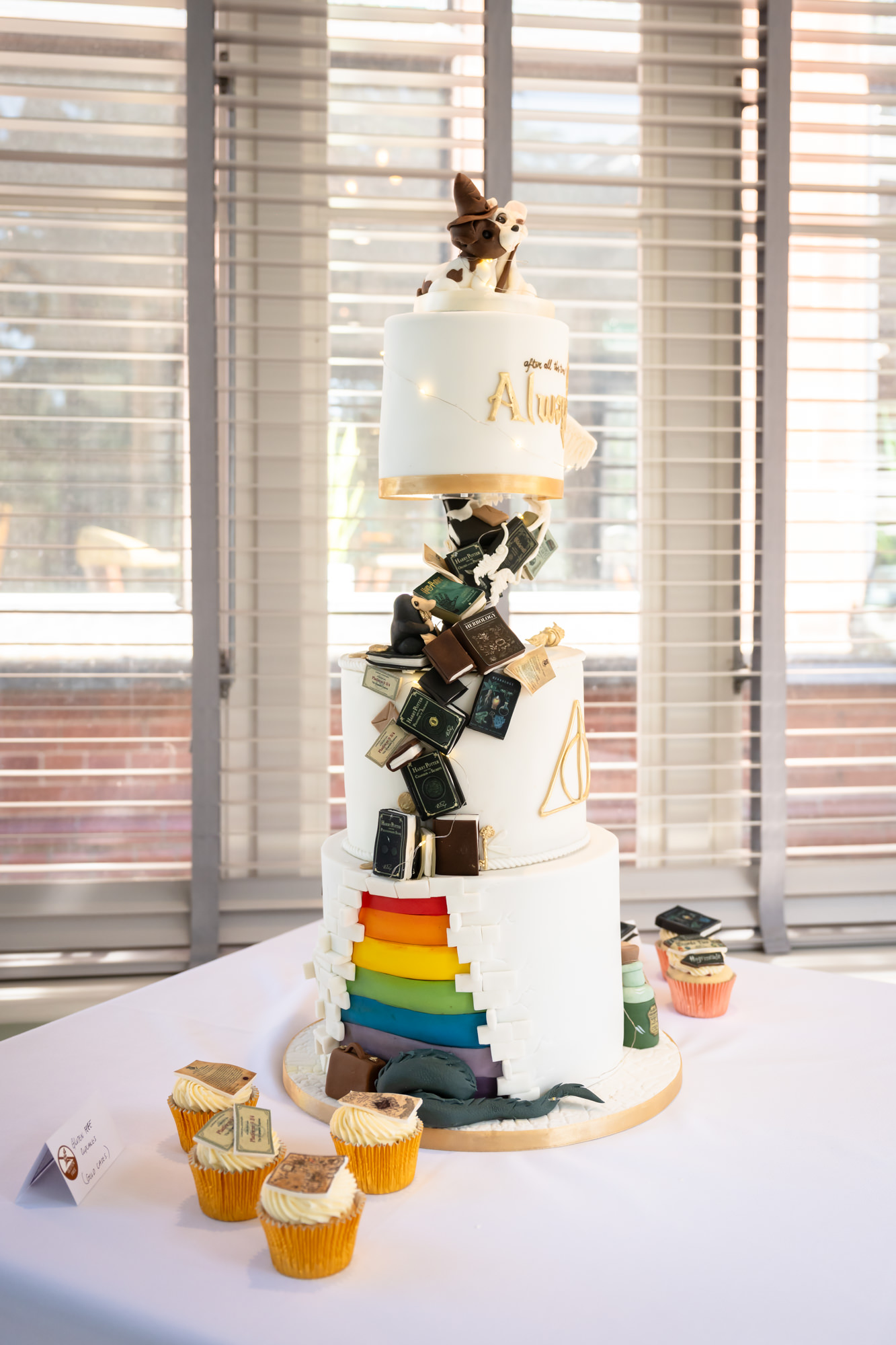 Marc and Dom's three-tier Harry Potter wedding cake at The Oakfield, with cascading edible books and a rainbow layer.