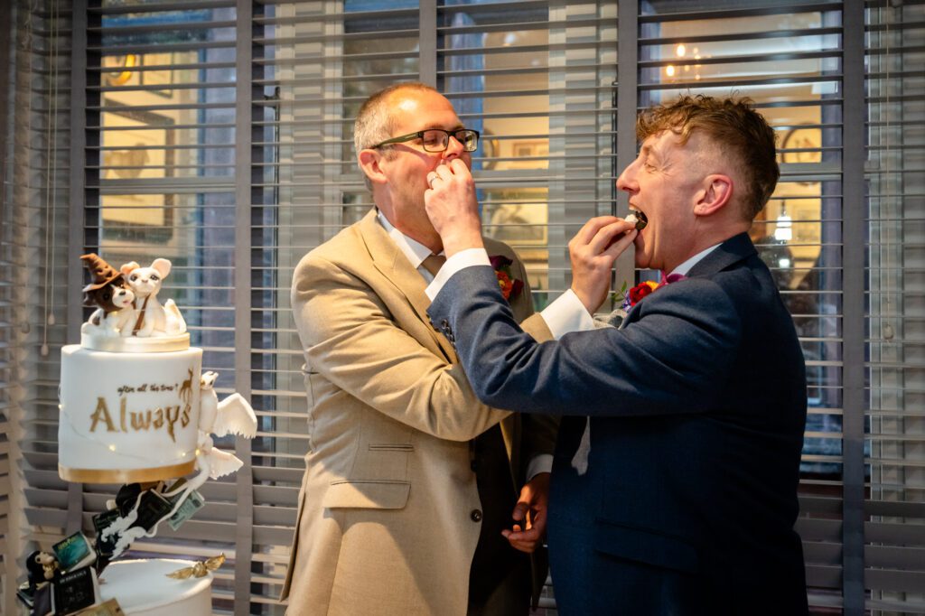 Marc and Dom feed each other a piece of cake.