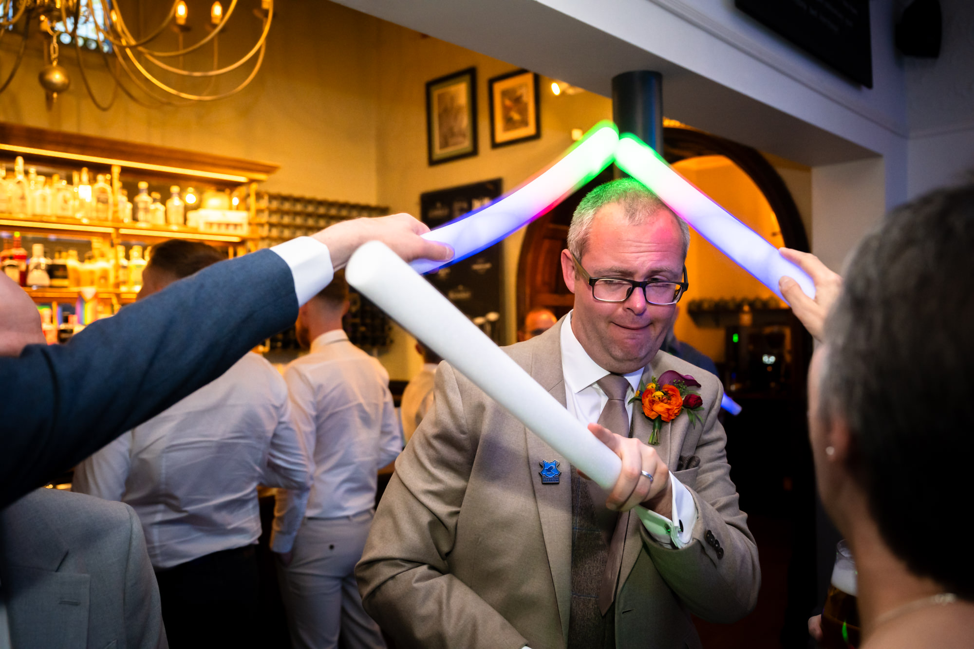 Guests fighting Dom with glow sticks on the dance floor.