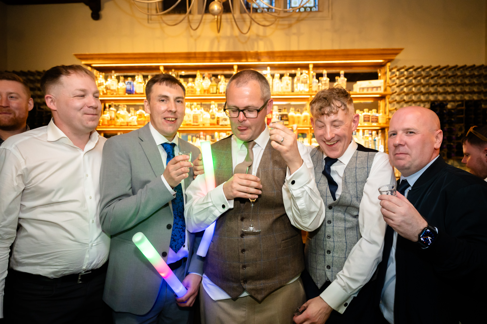 The grooms and their friends raise a toast at the bar.