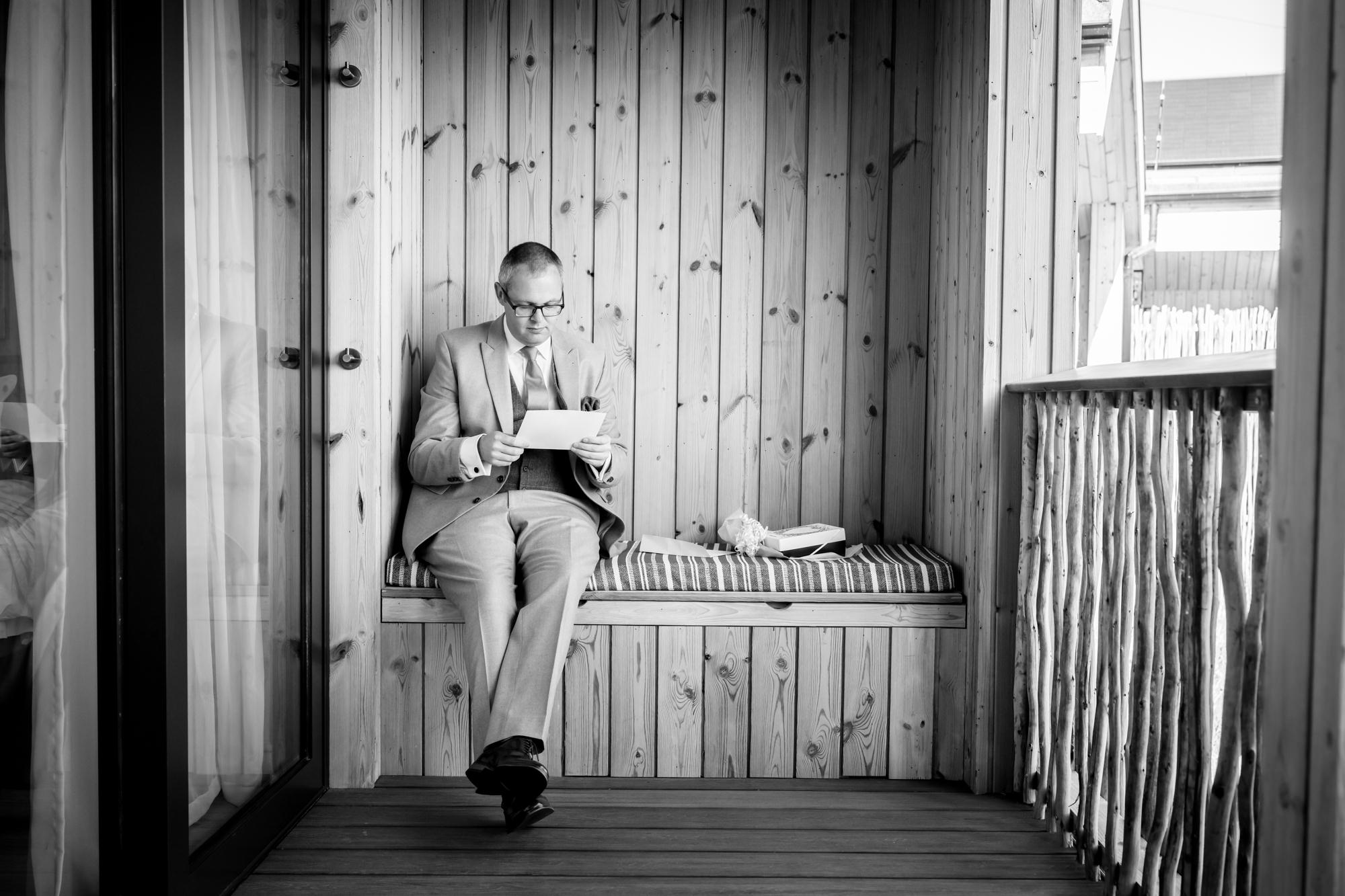 Dom reads a card on the lodge balcony during prep at The Reserve.