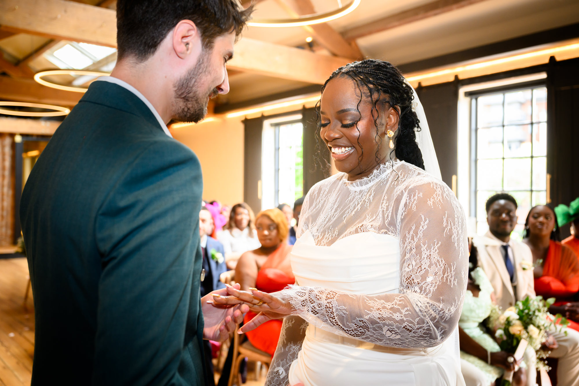 The bride placing a ring on the groom's finger during the ring exchange at their wedding ceremony in the Brindley Room at The Castlefield Rooms.
