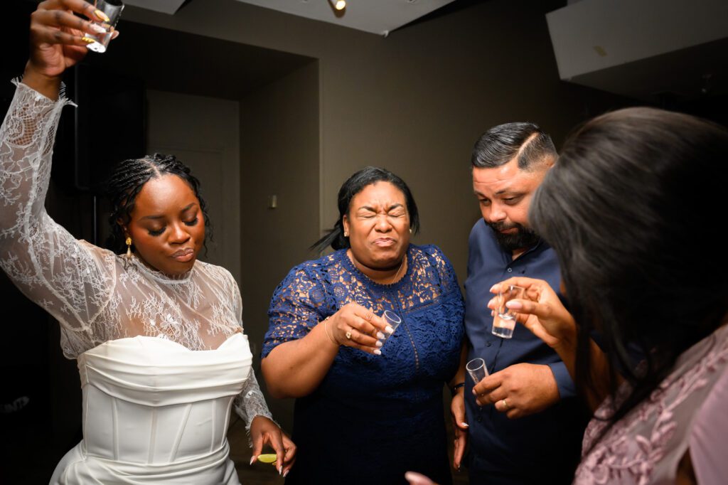 The bride doing tequila shots with wedding guests during the evening reception at The Castlefield Rooms.