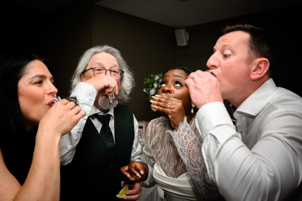 The bride and wedding guests doing tequila shots together at The Castlefield Rooms during the evening reception.
