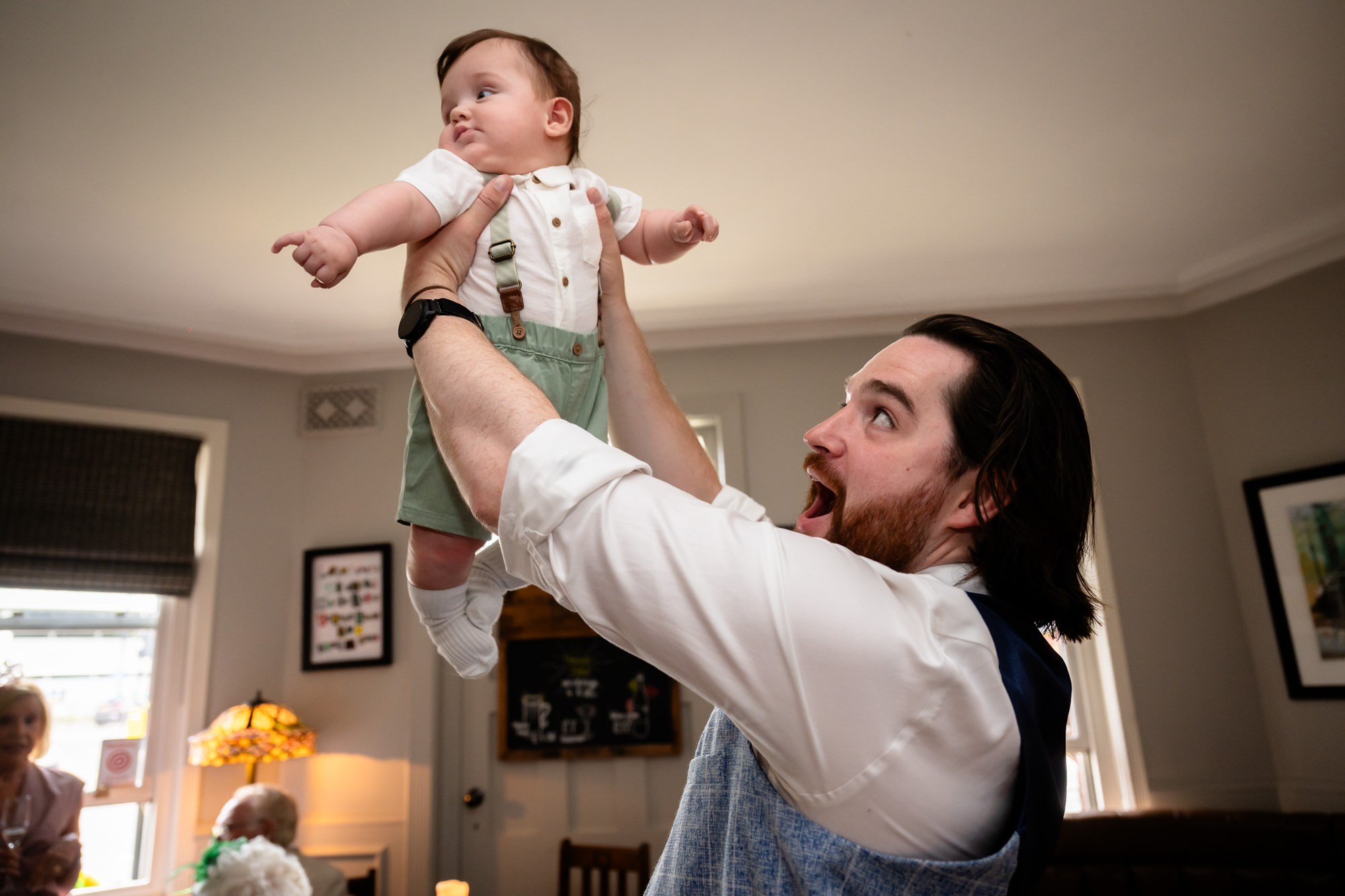 Wedding guest tossing a baby into the air and laughing at the Black Friar Salford