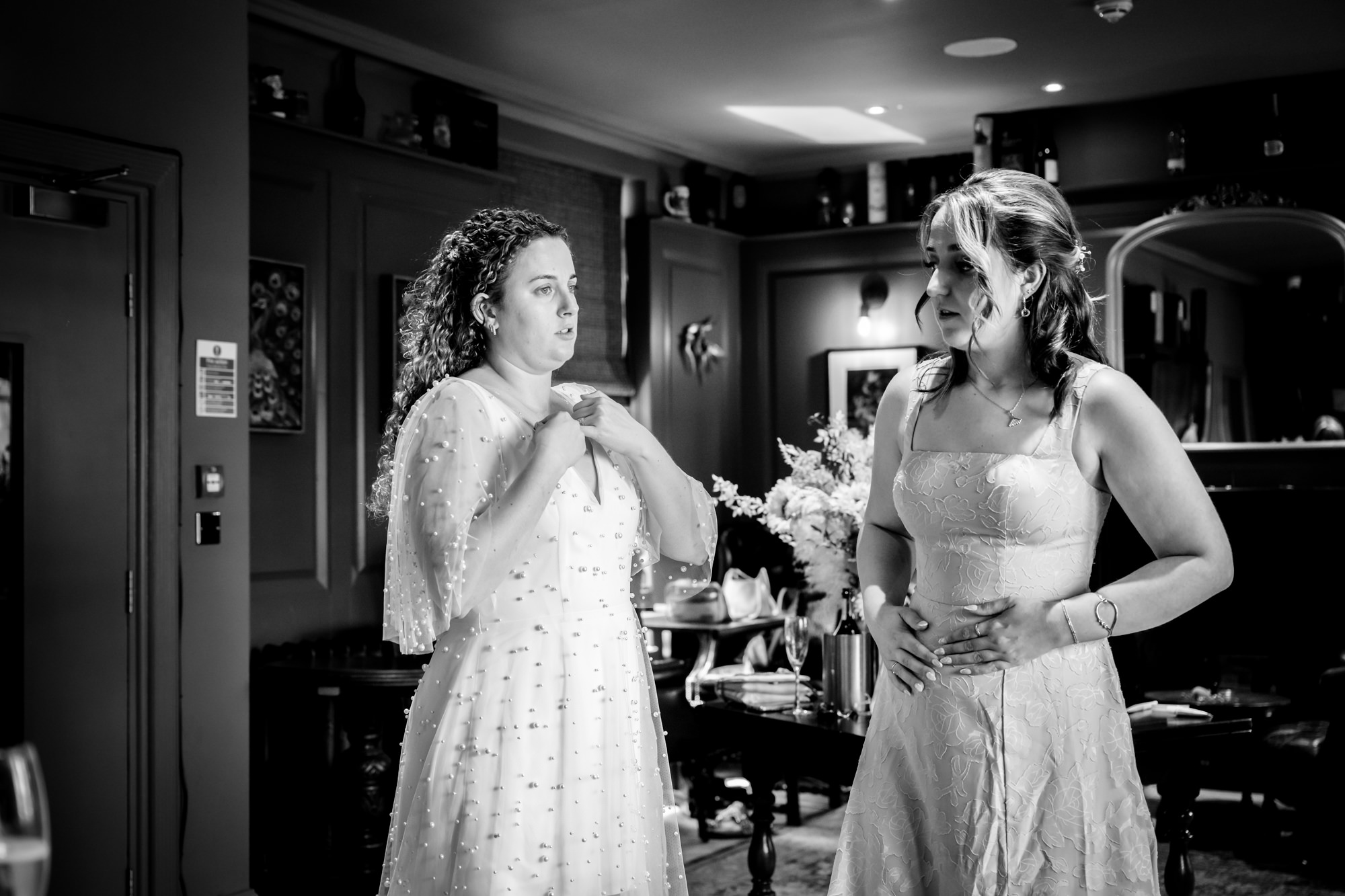 Bride and bridesmaids looking stressed while getting ready, black and white