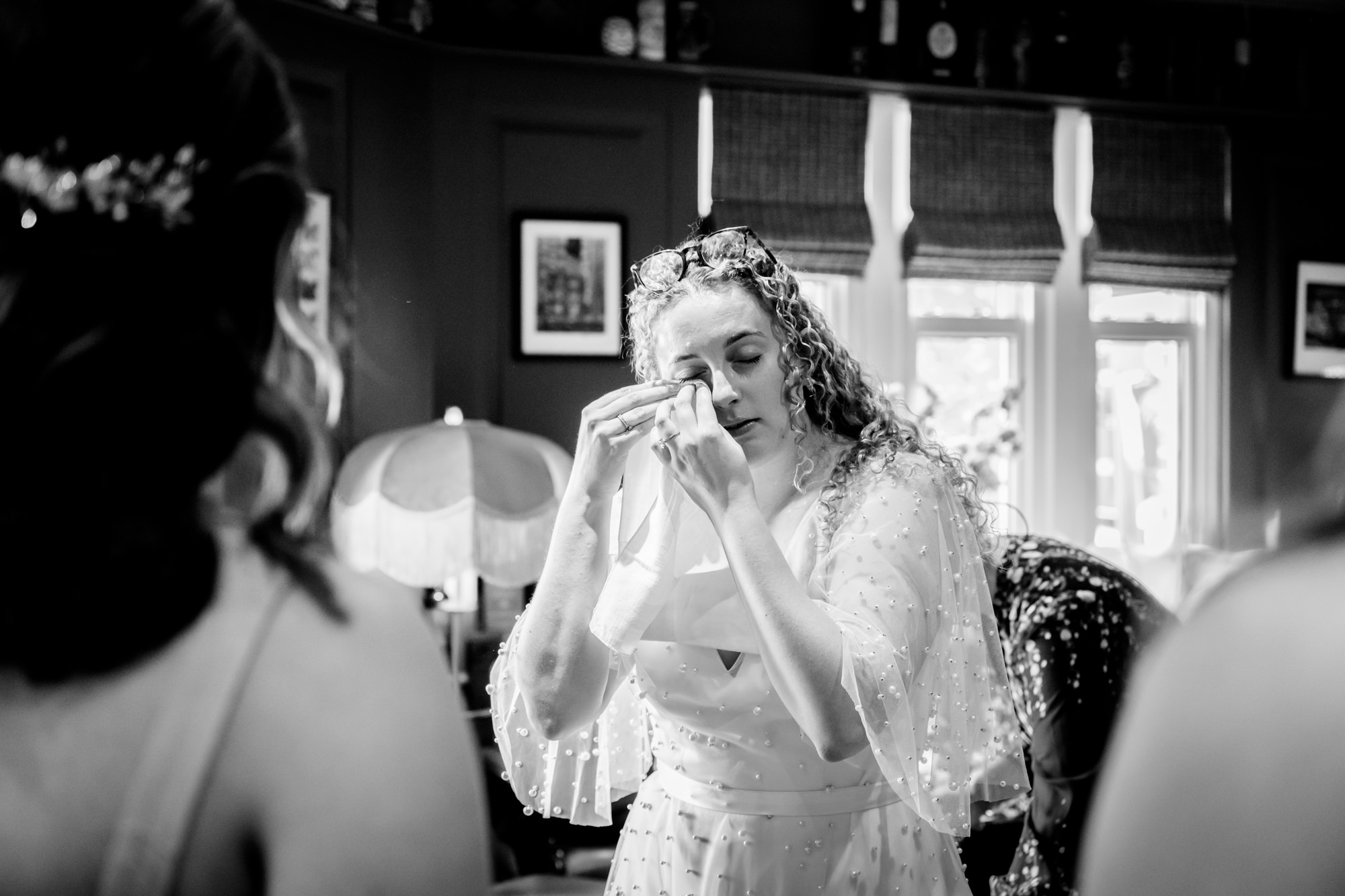 Bride wiping away a tear before the wedding, black and white