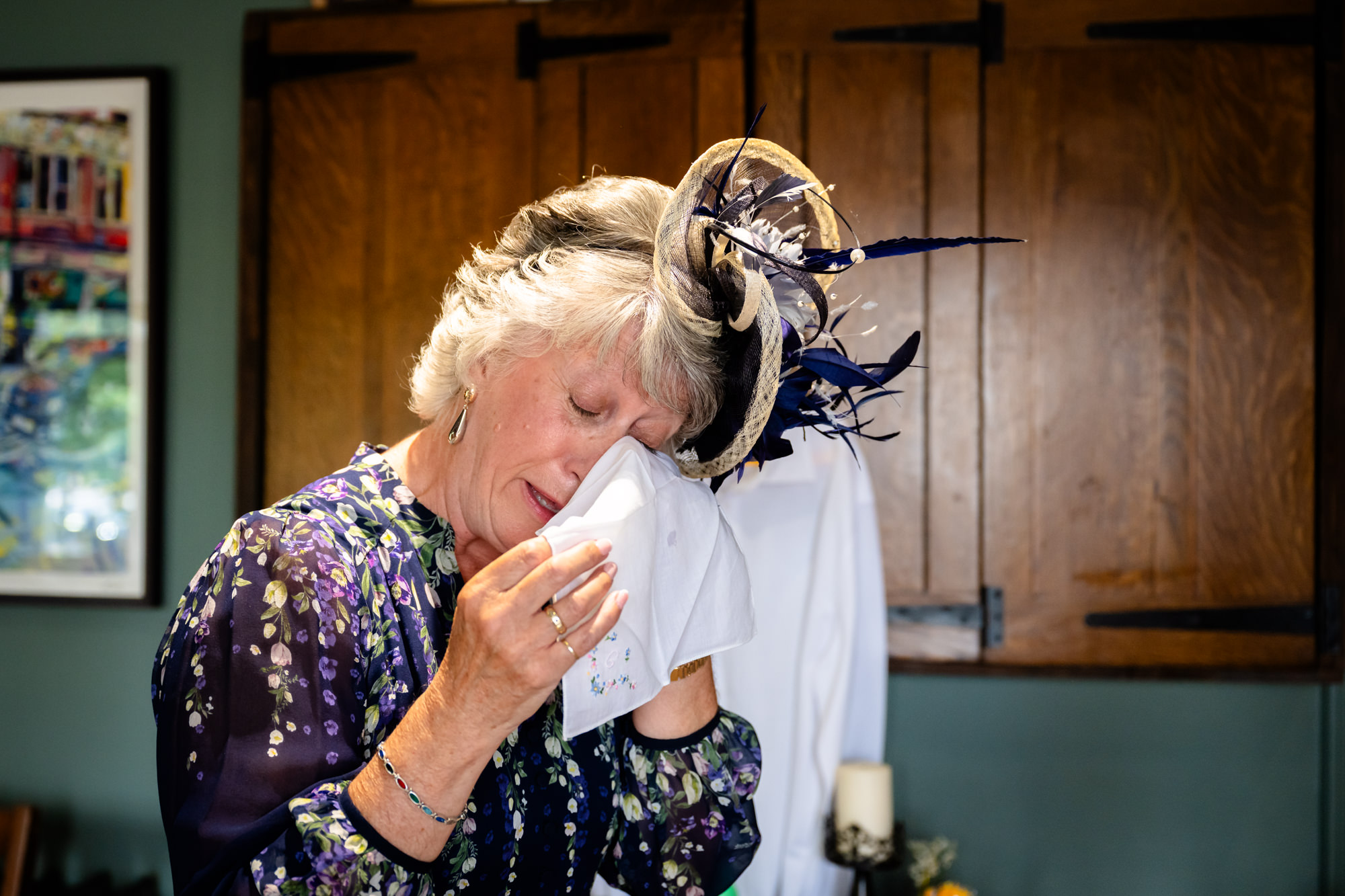 Mother of the bride wiping away a tear with a handkerchief, black and white